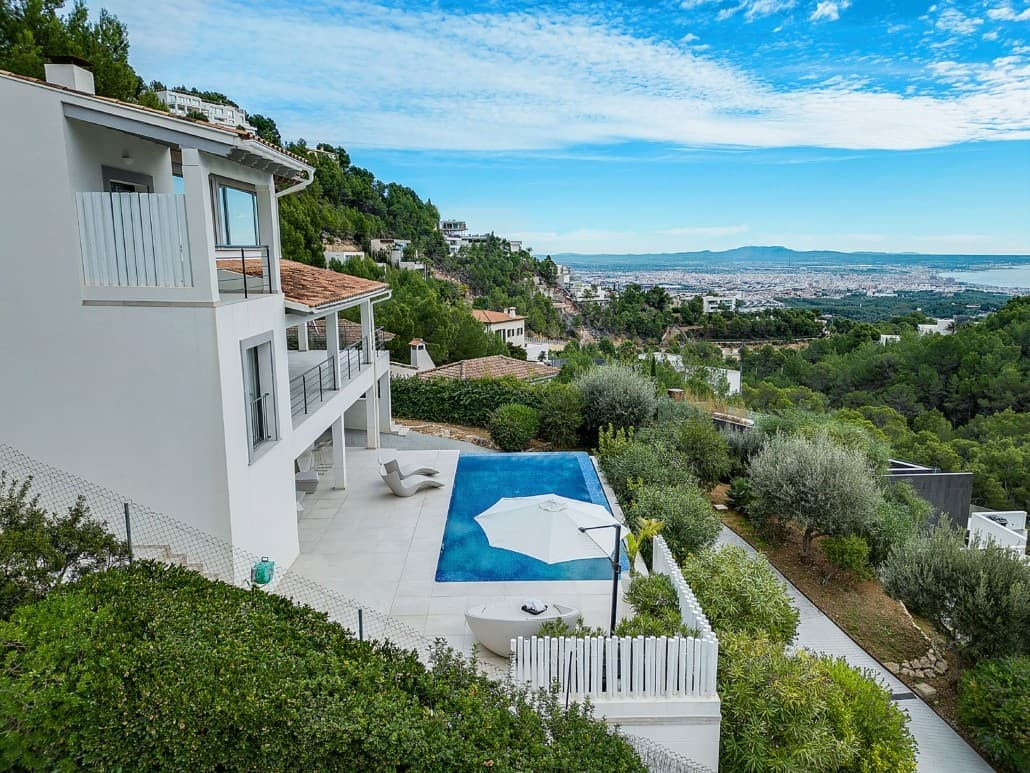 Esta villa bellamente renovada en Son Vida se distribuye en tres plantas y ofrece espectaculares vistas a Palma y al mar desde casi todas las estancias. Se accede a través de un camino privado con jardines paisajísticos. La entrada conduce a un garaje al mismo nivel que la piscina infinita y la terraza, ideal para relajarse con vistas panorámicas.

 La planta baja incluye un posible spa, acceso directo al garaje y ascensor o escalera a las plantas superiores. La entrada principal se encuentra en la primera planta, accesible por una escalera exterior. Aquí encontrará un dormitorio de invitados con baño privado (actualmente convertido en despacho), un aseo y un salón-comedor diáfano con techos altos, chimenea y dos amplias terrazas, ideales para disfrutar del sol o la sombra durante todo el día. Unas puertas de cristal de suelo a techo conectan el interior con los espacios exteriores, potenciando la luminosidad y las vistas.

 Una cocina moderna, una despensa y un dormitorio adicional con balcón francés completan esta planta. En la planta superior hay tres dormitorios más con baño privado, incluyendo una suite principal y una galería con una segunda chimenea y sala de estar. Un elevador de plataforma conecta con la cocina inferior para mayor comodidad.

 La casa cuenta con aire acondicionado y acabados de alta gama, lo que la convierte en una excelente inversión a solo 10 minutos del casco antiguo de Palma y a 20 minutos del aeropuerto. Excepcional en su categoría, esta villa combina privacidad, lujo y vistas panorámicas en una propiedad excepcional.