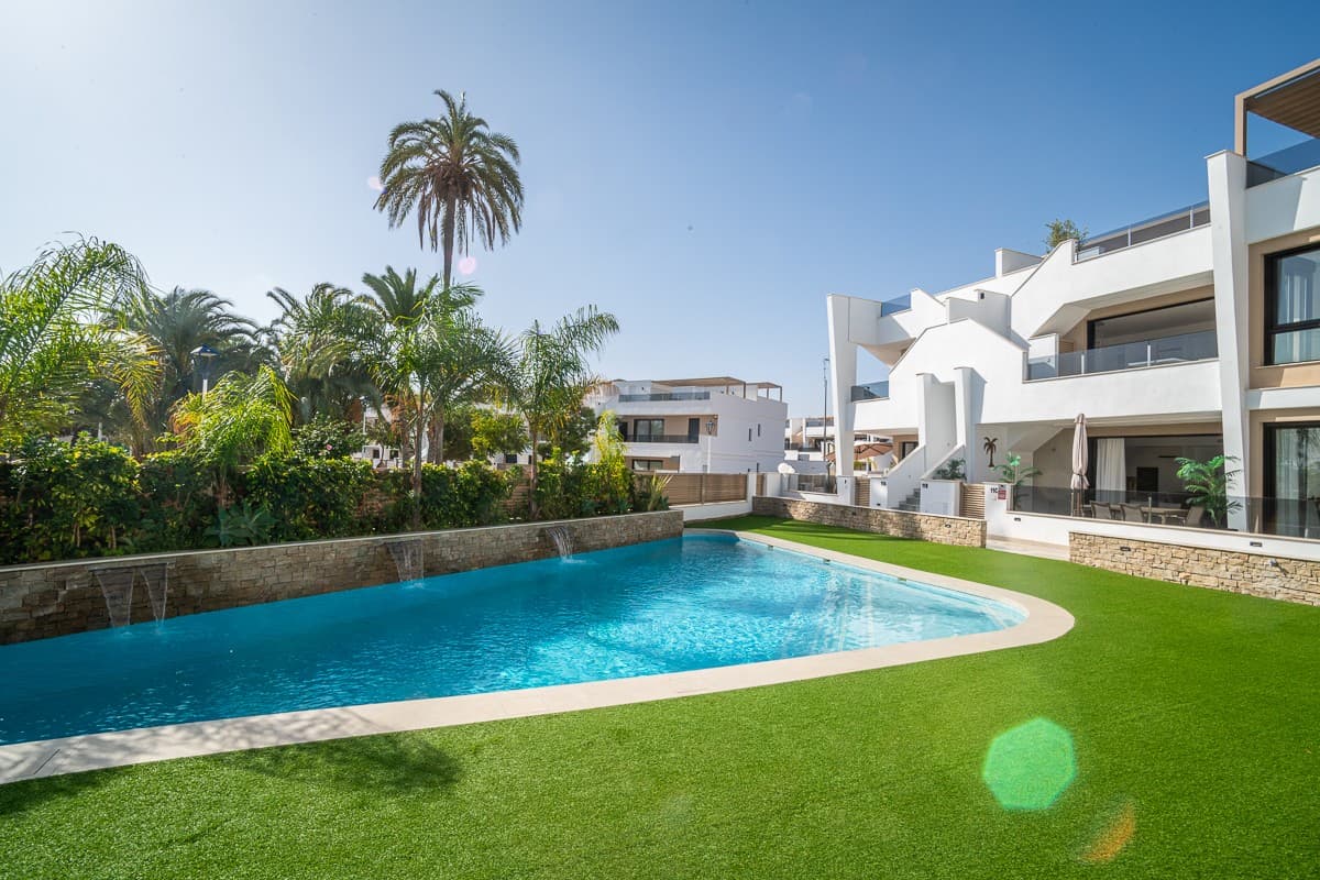 We are delighted to present this exceptionally beautiful penthouse in San Pedro del Pinatar, Murcia. This modern top-floor bungalow apartment guarantees a luxurious and carefree lifestyle. Situated in a charming coastal village and a short walk from all the essentials – such as Consum, the weekly fresh produce market, and the lively town center – you'll enjoy an absolute prime location where comfort and convenience come together. Unique in its kind What truly sets this penthouse apart from other homes in the complex is the high-quality finish, the attention to detail, and the many exclusive extras. Moreover, this home is the only one with a private staircase to the solarium, ensuring maximum privacy and comfort. Upon entering, the open, airy layout is immediately striking. Large, fully retractable windows disappear into the wall, seamlessly blending indoors and outdoors, bathing the living space in natural light. Fly screens are fitted throughout, a major plus for everyday use. Layout and facilities The penthouse features three spacious bedrooms ( sleeping up to 7 , ideal for rental!) and two modern bathrooms with underfloor heating, a walk-in shower, and high-quality fixtures. All bedrooms feature built-in wardrobes, TV connections, and shutters for added comfort and privacy. The kitchen was designed completely differently from the standard layouts in the complex: a kitchen island that extends into a dining table , high-quality equipment (dishwasher, hob, refrigerator, oven, microwave, extractor hood, wine cabinet), ample storage space thanks to custom-made cabinets. The house is fully air-conditioned , both in the living area and in the bedrooms. Private solarium – your own luxury oasis The spacious 84 m² solarium is accessed privately via your own staircase, completely hidden from view from the neighbors. Here you will find: a fully equipped outdoor kitchen with refrigerator, hob, grill plate and automatic roller shutter, built-in sun blinds with integrated LED spotlights , built-in music boxes in the wall, preparation for connecting a jacuzzi , panoramic view of a green park that may never be built on , which guarantees lasting privacy. Additional assets Toldo placed on the small terrace Communal swimming pool (heatable) Spacious separate storage room with boiler, washing machine/dryer connection and extra guest toilet Parking space included Only 2 years old → benefit from only 8% tax instead of 10% Complex of only approximately 22 apartments No view, quiet location Optional furniture The house can be purchased fully furnished and bicycle storage is also optional. Are you looking for a move-in ready holiday home, a comfortable permanent residence, or an excellent investment opportunity with strong rental potential? Then this penthouse is the perfect choice. Plan your visit today and discover for yourself all the luxury this home has to offer.