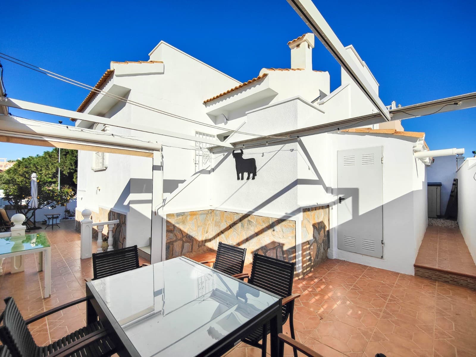 This beautiful semi-detached villa is located on a 200 m² plot in a quiet and highly sought-after area of Ciudad Quesada, part of Rojales. Positioned directly in front of a spacious green area, the property enjoys completely open views, excellent privacy and a peaceful environment.The villa is distributed entirely on one level and is elevated with an air chamber underneath, providing improved insulation and comfort throughout the year. It offers 2 bedrooms with fitted wardrobes and 2 full bathrooms, one of them en-suite. The living room is spacious and filled with natural light thanks to its west orientation, and it is equipped with air conditioning. All rooms benefit from ceiling fans. The kitchen is independent and fully equipped.Outside, the property features a private garden of approximately 100 m², ideal for enjoying the Mediterranean climate, as well as a 15 m² west-facing porch overlooking the green area. There is also a 20 m² private solarium, perfect as a relaxation space, off road parking for the car, and a storage/laundry room. The facade and exterior walls have been recently painted, and the property is sold furnished, including white goods.The residential complex offers a communal swimming pool. Located close to the centre of Ciudad Quesada, with all amenities, shops and restaurants within easy reach.An excellent opportunity as a permanent residence, holiday home or investment property on the Costa Blanca South.