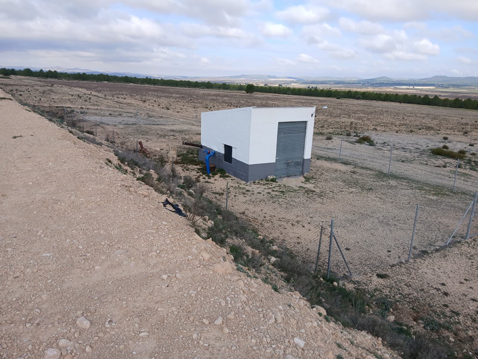 600,000m2 of land for sale, with water supply of 100,000 liters per year, there is also electricity. The possibilities with this land are endless. You can plant olive trees, but it is also suitable for the installation of a solar panel park. Currently there are grape vines on a part of the land, this could also be expanded. Furthermore, there is almost no vegetation. There are two small buildings, in one of them you will find the pump for the water supply, and there is also electricity. These buildings are legalized. You can built a house here as well.