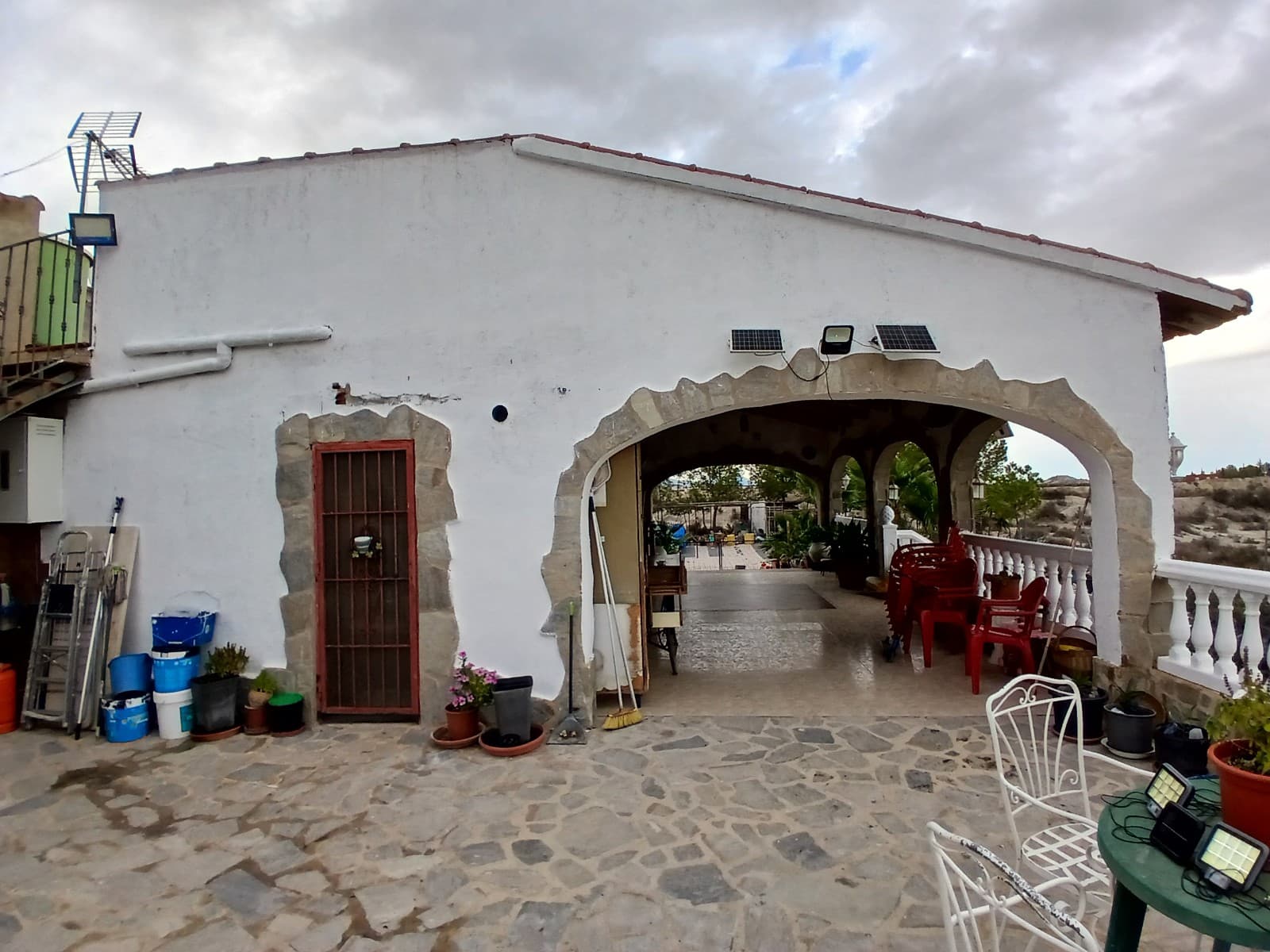 Large detached villa with plot of 11,188m2 on top of the mountain, with no neighbors around it. You overlook the town and surrounding mountains and can see some houses in the distance. The plot includes 140 olive trees, several palm trees, orange, fig, lemon and grapes. There is also a chicken coop.

The villa of 350m2 is divided into 2 residential houses, each with its own entrance. The upper house is already fully finished, the lower house is partly finished, but offers many possibilities.

You come via a staircase on the large veranda of 36.8m2 here is the front door. You enter the house in a large open living room with kitchen of 52.6m2 with wood stove. The kitchen has a large 6 burner stove with oven and a large fridge-freezer there is also a large bar where you can eat / drink. Furthermore, there are 3 bedrooms, the large one is 17,2m2 and there are 2 smaller ones of 10m2 each), also there are 2 bathrooms. The house has double glazing, shutters and mostly with mosquito nets.

The house is offered partly furnished.

The 2nd house, which still needs to be finished, you enter through a large garage door, the entrance is 20.5m2. On the left is a largely finished bathroom (only the suspended ceiling needs to be put in) of 7.7m2. Then there is a large open space of 38.8m2 where you could make a living room with kitchen, although the kitchen can also be placed in one of the other rooms. There is also a room which is currently used as a workshop of 21.6m2 and 2 additional rooms of 16m2 and 18.8m2. The house is double glazed and electricity has been installed everywhere.

The houses have drinking water, a septic tank and are equipped with electricity by means of solar panels (3000 watts) with 2 large batteries, this can be expanded as needed.