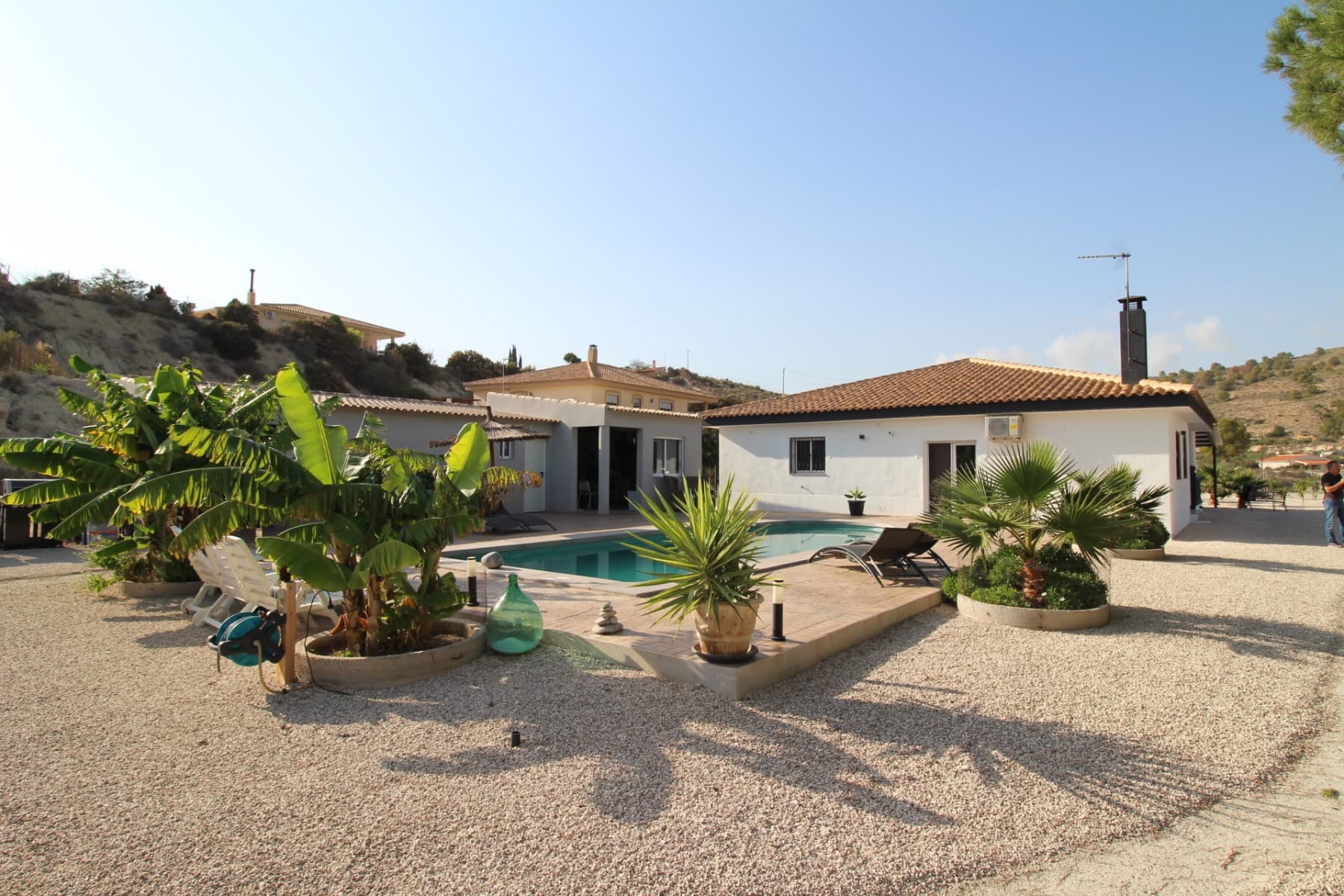 This pretty villa is located just 2 km from the town with all amenities and less than 3 km from the spa. It has been tastefully renovated and is truly superb. It comprises an entrance hall, a spacious living area, an open-plan kitchen, a utility room, a storeroom as well as 3 bedrooms and 2 bathrooms, one of which is en suite. There is a covered terrace at the side of the house and a bay window leads directly from the living room to the magnificent swimming pool. To the side of the pool is a 50m2 casita with a superb kitchen, bathroom and storage space that could easily and inexpensively be converted into an additional bedroom. The garden has been carefully landscaped with many local plants and fruit trees (palm, banana, avocado, passion flower, cherry, fig, orange, lemon etc). There is also a car port for 3 vehicles and the entrance gate has an electric motor. This villa has all the modern comforts: fibre optics for internet, drinking water, electricity, air conditioning. This is truly a ‘coup de coeur’ villa that deserves to be seen to be fully appreciated. 50 minutes from Alicante airport and the beaches, 20 minutes from Murcia.