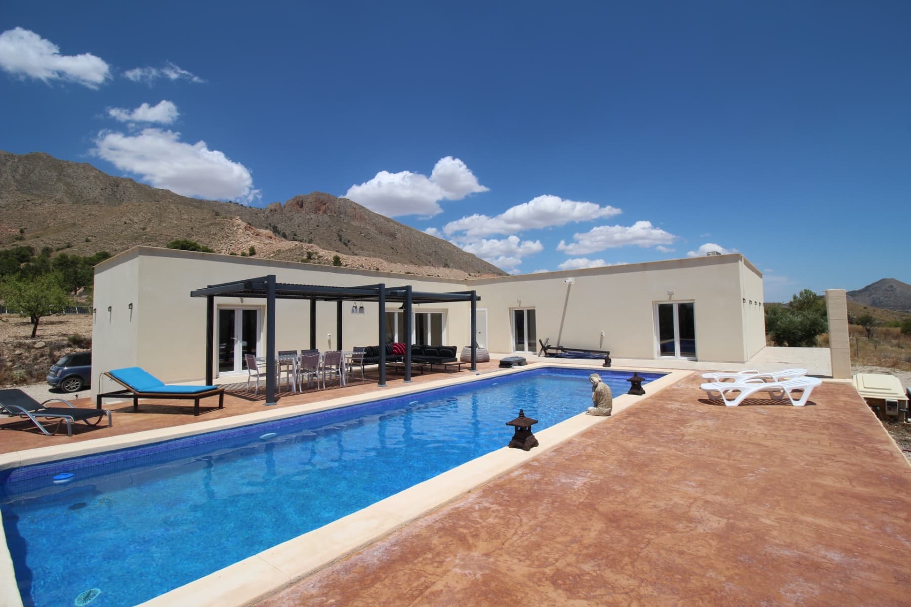 This property is located high up in a quiet location with extraordinary views of the mountains and the valley of Hondon. The land of more than 12000 m2 is planted with many olive, almond and fig trees. There is still plenty of room for other fruit trees. The villa built only 4 years ago is almost new since occupied only a few weeks during school holidays. It consists of an entrance hall, a living space (living room/ dining room/ open kitchen) of 70m2 with 2 bay windows each overlooking a terrace. There is also a third terrace on the side to enjoy the sun from breakfast. There are 4 bedrooms of beautiful dimensions and 3 bathrooms, 2 of which are directly en suite. One of the rooms is located at the end of the building and is completely independent. On the front, a large terrace overlooks the magnificent swimming pool (12,5x4 m) heated by a heat pump and offers truly incredible views. On this terrace is a pergola to enjoy the landscape while being in the shade. This house enjoys all modern comforts: water, internet with fiber optics, centralized hot/cold air conditioning, ceiling fan, alarm system with peripheral detectors, one gaz boiler and one elecgtrci boiler brand new.. It can be connected to the electrical grid that runs right in front of it, but it is completely autonomous thanks to photovoltaic panels and lithium batteries (10kw). It will be sold mostly furnished (inventory available) Energy certificate A. The village of Macisvenda with all amenities is less than 5 minutes away, the beaches 45 minutes away, the airports of Murcia or Alicante 50 minutes and the superb city of Murcia 35 minutes. You really have to come and see to realize the beauty of the place