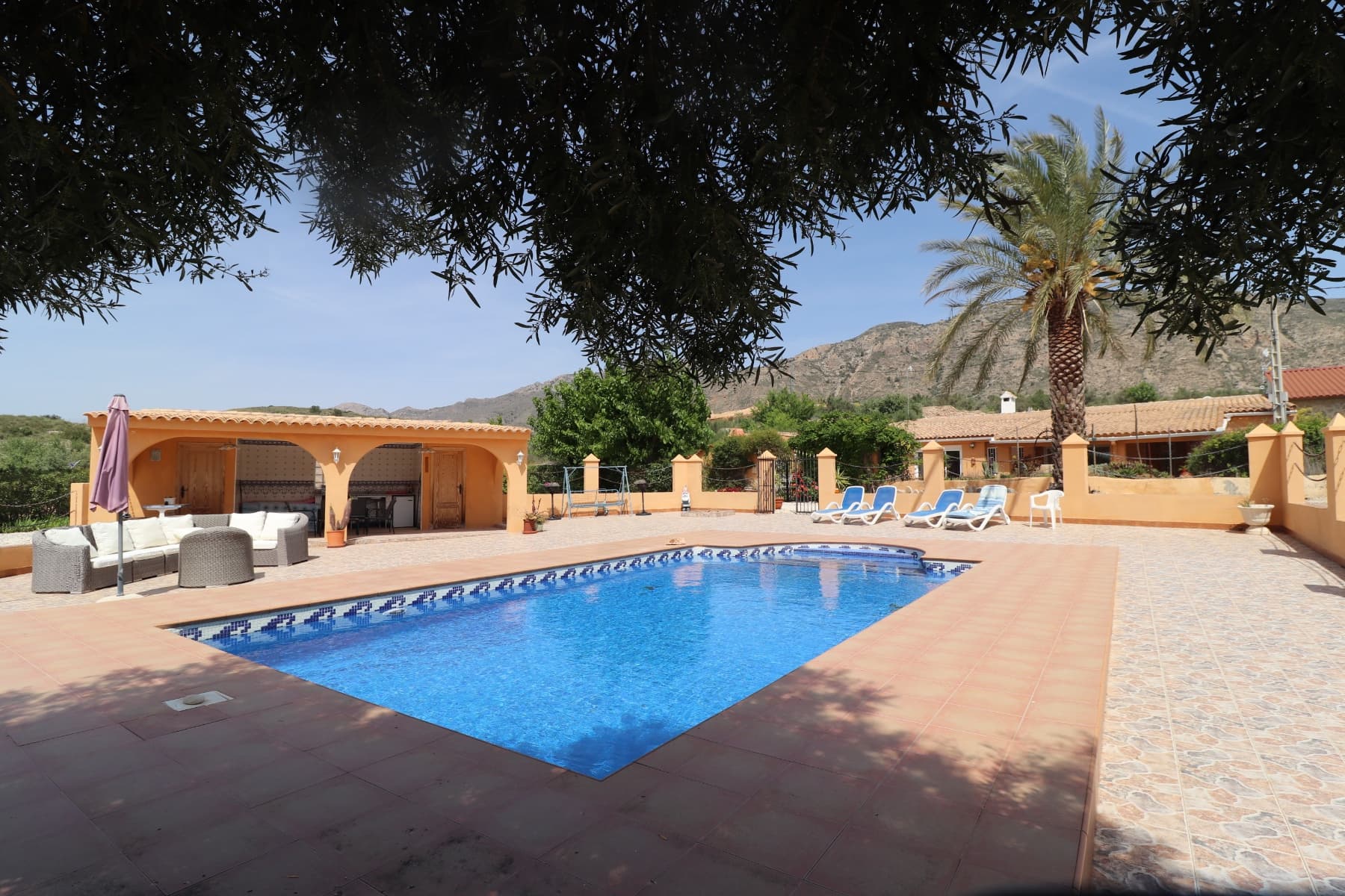 This beautiful property is located in a superb quiet location just a few minutes drive from the 2 villages of Hondon de las nieves and Hondon de los frailes with all amenities. There are more than 400m2 of built area including the main house with a part cave, a pool area with porch, summer kitchen, technical local and toilet, storage, a laundry room and a double garage with workshop that could easily be converted into a separate apartment. The main house consists of several livings, dining room, a kitchen, a pantry and 5 bedrooms and 2 bathrooms. The rooms are in the cave, which brings charm and a lot of freshness in summer. In front of the house, the space is occupied by a covered terrace (30m2) and a spacious terrace with barbecue area. The pool is superb and is located right in front. The house is connected to the water and electricity network, and has internet and a hot/cold air conditioning unit. It is a rare property, with a lot of charm and that must be seen to realize