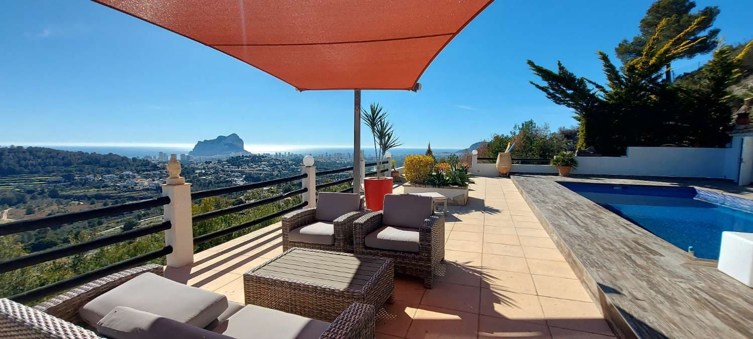 Villa en venta en Calpe situada en una zona residencial consolidada, a 5 Km del centro urbano de Calpe y de sus magníficas playas, todo tipo de comercios, servicios médicos y una amplia oferta de ocio y restauración.La villa se ha reformado totalmente con mezcla de estilo moderno con estilo mediterráneo y disfruta de unas magníficas e increíbles vistas panorámicas al mar, al Peñón de Ifach y a todo Calpe. Muy, muy luminosa (orientación Sur) y muchísima privacidad-La villa se ha construido en una amplia parcela de 2.100 m2 y tiene una superficie construida de 184 m2. Distribuida en 2 plantas:- En la planta principal tenemos el porche y un amplio vestíbulo de entrada, dormitorio principal con baño en-suite y amplios armarios, trastero-despensa, amplio salón-comedor-cocina (65 m2) y porche que se fusiona con la impresionante terraza exterior de 216 m2 con piscina rectangular de 8x4 metros, un porche de madera con zona de chill-out y relax, ducha exterior, aseo, cocina de verano y barbacoa, lavadero-sala de máquinas y un trastero que también hace funciones de cuarto dormitorio auxiliar. Se accede a la planta alta a través de una escalera interior.- En la planta superior tenemos el pasillo, 2 amplios y luminosos dormitorios y 1 baño con plato ducha.La villa ha sido recientemente renovada en su totalidad y destaca por sus vistas, por su luz, por su tranquilidad y privacidad y por sus magníficas zonas exteriores.Está equipada con calefacción central (sistema aerotermia de bomba de calor que ofrece la mayor eficiencia y mejor rendimiento) y con aire acondicionado. También dispone de amplia zona de aparcamiento exterior para 2 vehículos (cubierta tipo vela) ubicada estratégicamente junto a la entrada principal. El jardín de bajo mantenimiento, con muchas plantas, cascada en la zona de la piscina y terraza chill-out para disfrutar de los más de 300 días de sol al año que le ofrece Calpe.Le invitamos a conocer esta magnífica villa. No le defraudará.