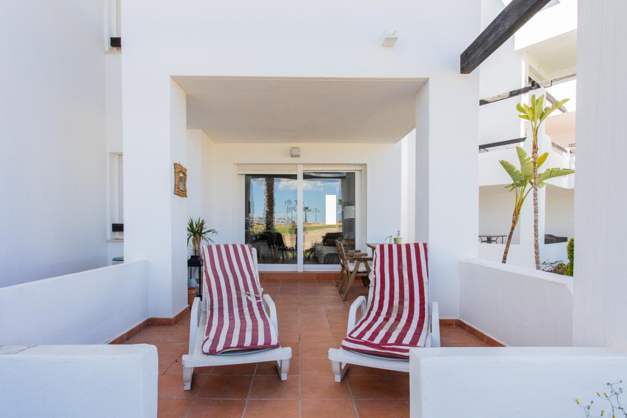 This charming ground-floor home offers the ideal combination of vacation and quality of life. With a privileged location just 10 minutes from Murcia and the beaches, you'll enjoy the tranquility of a complex with 24-hour security and landscaped gardens. Relax in the communal pools and enjoy the convenience of on-site parking. The south-facing apartment guarantees natural light year-round and a pleasant temperature even in winter. The private terrace is the perfect place to enjoy the stunning views of the golf course. It is sold fully furnished, with a fully equipped kitchen and air conditioning for your comfort. With 75 m² built area and 65 m² usable area, this home features 2 bedrooms, 1 bathroom, and built-in wardrobes, all in excellent condition. Built in 2008, this apartment combines modernity and functionality. Electric heating via a hot/cold pump ensures a cozy atmosphere in any season. The building also has an elevator for your convenience. Don't miss the opportunity to visit this wonderful space.