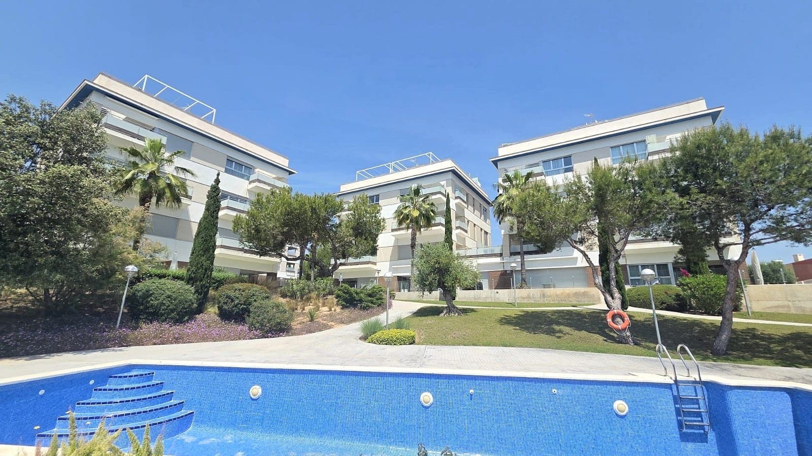 Discover this exceptional 3-bedroom, 2-bathroom ground-floor apartment located in the highly sought-after area of Villamartín – Los Dolses, Orihuela Costa. Immaculately presented and designed with contemporary style, this beautiful 100 m² home offers the perfect blend of comfort, elegance, and convenience.The apartment features a bright and spacious open-plan living and dining area, enhanced by a full glass frontage that floods the space with natural light. The modern kitchen is seamlessly integrated and complemented by a practical seperated Laundry - utility room. The master bedroom includes an en-suite bathroom with a walk-in shower, while all bedrooms benefit from built-in wardrobes.Step outside to enjoy a generous 52 m² south-west facing tiled terrace, offering lovely views over the landscaped gardens and communal pool, along with a subtle glimpse of the sea. The property also boasts a 26 m² private rear garden perfect for storage. Both outdoor spaces provide direct access to two separate communal swimming pool areas, creating a perfect setting for relaxation and outdoor living in the sun.This property is sold fully furnished and equipped to a high standard, including central air conditioning (hot and cold), mosquito nets, alarm system, internet connection, private dedicated parking in the community, and an external storage room on the roof terrace —ensuring both luxury and practicality.Situated within the secure gated community of El Mirador de Villamartín, the apartment is ideally located just a 5-minute walk from supermarkets, restaurants, and bars. A short 5-minute drive brings you to Zenia Boulevard, one of the largest shopping centres in the region, as well as the beautiful sandy beaches of Orihuela Costa, including La Zenia and Playa Flamenca. Golf enthusiasts will appreciate the proximity to four renowned golf courses: Villamartín, Campoamor, Las Ramblas, and Las Colinas.Orihuela Costa, located on the Costa Blanca South, is celebrated for its stunning coastline, vibrant atmosphere, and excellent amenities. Whether you're seeking a permanent residence, holiday home, or investment opportunity, this property offers an outstanding lifestyle in one of Spain’s most desirable coastal areas. Viewing is highly recommended !!