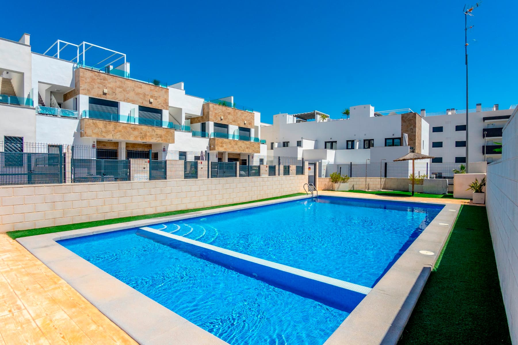 For sale a very spacious semi-detached Triplex house with a modern design in Villamartín, one of the most demanded areas of Orihuela Costa.Located in the prestigious golf area of Villamartín, this magnificent property perfectly combines contemporary design, comfort, privacy, and quality of life. It has been designed for those who wish to enjoy the Mediterranean climate all year round, surrounded by tranquility, nature, and all essential services just a few minutes away.The property offers 134 m² of living space, carefully distributed to provide bright, spacious, and functional rooms. From the very first moment, its modern architecture, contemporary finishes, and the pleasant sense of space throughout the home stand out. Upon entering the property, you are welcomed by a large private terrace, ideal for enjoying outdoor breakfasts, relaxing moments, and sunny afternoons during most of the year.Inside, the heart of the home is its spectacular open-plan living and dining area with a contemporary-style kitchen. This bright and airy space has been designed to encourage family living and social gatherings. While cooking, conversations, laughter, and unforgettable moments naturally unfold, creating a warm and inviting atmosphere. The seamless integration of the living room, dining area, and kitchen provides a perfect balance of space, functionality, and modern living.On the ground floor, there is also a fully equipped bathroom with a walk-in shower, offering convenience for both everyday family use and visiting guests. In addition, a discreet laundry area has been cleverly integrated beneath the staircase, maximizing the available space. On the upper floor, you will find three spacious bedrooms designed to provide maximum comfort and privacy. The property features three elegant bathrooms, two of which are en-suite, offering additional convenience for the owners.Large windows allow abundant natural light to flow into the property throughout the day, creating warm and welcoming spaces connected to the surrounding environment. From the terraces, you can enjoy pleasant views of the green areas, the communal spaces, and, in the distance, the blue waters of the Mediterranean Sea on the horizon.One of the property's greatest attractions is its privileged natural setting. Directly in front of the home lies a large protected green area, providing a unique sense of openness, privacy, and connection with nature. The property also features inviting terraces and a fantastic private solarium where you can relax, sunbathe, or enjoy outdoor dining. From this elevated space, you can take in open views that convey a true sense of wellbeing, peace, and quality of life.The southeast orientation is one of the most desirable features of this home. It allows residents to enjoy sunlight for much of the day, while the pleasant Mediterranean breeze naturally refreshes the living spaces, creating an exceptional atmosphere throughout the year.The property is sold almost fully furnished and equipped with appliances, ready to move into. Only certain custom-made furniture, decorative items, paintings, and the owners' personal belongings are excluded from the sale.The residential complex offers an excellent quality of life thanks to its beautifully maintained communal areas. Residents can enjoy a large communal swimming pool surrounded by landscaped gardens, perfect for walking, relaxing, exercising, or simply admiring the spectacular sunrises and sunsets that characterize the Costa Blanca.The location is another major advantage. Within just 10 minutes walk, you will find supermarkets, restaurants, cafés, shopping centres, pharmacies, international schools, and all the services needed for everyday living. The renowned beaches of Orihuela Costa are approximately 10 minutes away by car, while several internationally recognised golf courses are located just a short distance from the property.Built in 2021, the property is in excellent condition, offering all the benefits of a modern and almost new home without the need for any additional investment.An exceptional opportunity for those seeking a bright, modern, and functional property in one of the finest residential areas of Orihuela Costa, whether as a permanent residence, holiday home, or real estate investment.A home where every detail has been designed to fully embrace the authentic Mediterranean lifestyle.