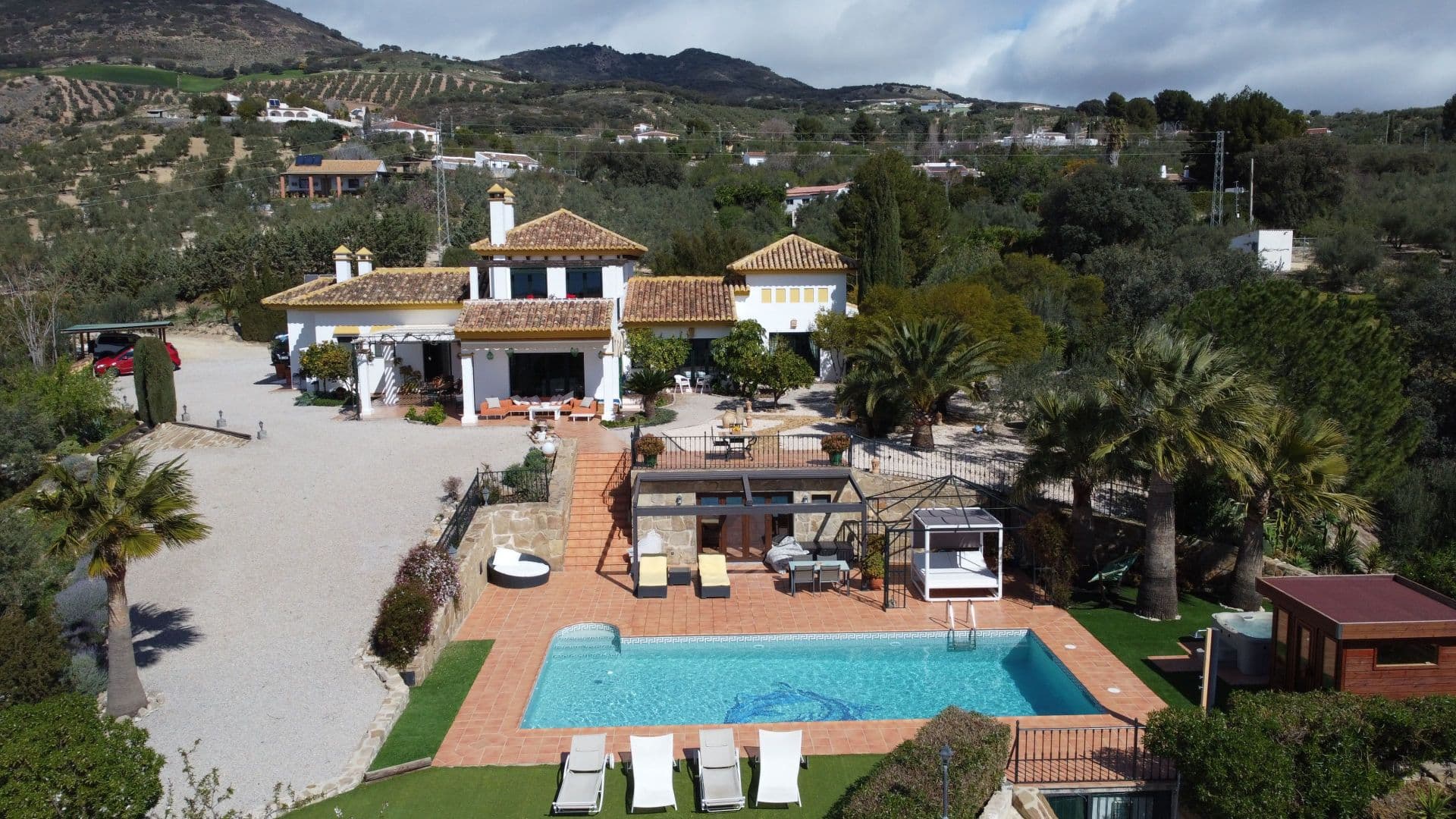 Enclavada en medio de la serena extensión de una extensa parcela de más de 40.000m², esta casa de campo de calidad personifica la mezcla perfecta de lujo moderno y vida sostenible. Con un floreciente olivar, esta propiedad no sólo ofrece un paisaje pintoresco, sino que también genera unos ingresos sustanciales gracias a su vanguardista instalación de energía solar. Al acercarse a la casa principal, el encanto es inmediato, con el ambiente acogedor del campo que te atrae. La residencia cuenta con 4 dormitorios y 4 baños, proporcionando un amplio espacio tanto para la familia como para los invitados. Suba las escaleras y descubra una oficina privada adornada con grandes ventanales que conducen a una encantadora terraza, que ofrece un refugio tranquilo para disfrutar de los impresionantes alrededores. El corazón de la casa se despliega con un salón cálido y acogedor, con una calorosa chimenea que atrae en las noches más frías. La cocina-comedor bien equipada es un paraíso culinario, donde las creaciones gourmet cobran vida. La calefacción por suelo radiante garantiza el confort en toda la casa, mientras que el aire acondicionado añade un toque de fresca elegancia a todas las habitaciones. En el sótano se esconde una joya: un amplio garaje que ofrece aparcamiento seguro y un trastero adicional. En el exterior, una serie de terrazas crean espacios encantadores para comer al aire libre, entretenerse o simplemente disfrutar de la belleza de la naturaleza. El encanto de esta propiedad se extiende más allá de la casa principal, ya que la casa de la piscina cuenta con su propio dormitorio y cuarto de baño. La amplia piscina, la sauna y el Jacuzzi prometen relajación, mientras que la pista de pádel invita a una competición amistosa. Relájese en las lujosas instalaciones y maravíllese con las cautivadoras vistas de los alrededores desde cualquier punto.Además de la casa, hay una instalación de placas solares que genera más de 3000 € al mes, mantenida por una empresa de Antequera. El sobrante se envía a Endesa.