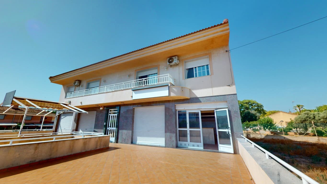 Just 400 meters from the beautiful beaches of the Mar Menor in Los Narejos, you’ll find this unique and versatile property offering a rare combination of living comfort, commercial space, and a prime location. This semi-detached building, situated next to a peaceful park, is perfect for those seeking space, flexibility, and the relaxed lifestyle of the Spanish coast.On the ground floor, there is a large commercial space featuring two wide display windows and a spacious front terrace. This area is ideal for running a business, whether it’s a shop, office, or hospitality venue, and its location—close to the beach and in a vibrant neighborhood—ensures excellent visibility and accessibility.The first floor houses a spacious and well-maintained apartment in excellent condition. The bright living room opens onto balconies at both the front and rear of the building. The fully equipped kitchen, three generous bedrooms, and a neat, functional bathroom offer everything needed for comfortable living. Air conditioning is installed in the living room and in one of the bedrooms.A staircase in the living area leads to the second floor, where you’ll find a charming studio apartment. This upper level includes a separate bedroom, bathroom, and storage room, along with a large terrace that’s perfect for enjoying the sun and views. Air conditioning is also available on this floor for added comfort.An additional highlight is the underground garage, with space for at least two to three vehicles. There is also a large, secure storage room—ideal for extra belongings or even a workshop.With its generous layout, flexible use, and exceptional location, this property is a true opportunity. Whether you’re looking to combine living and working, invest in a high-potential asset, or simply find a spacious home by the sea, this property has it all. Don’t miss out—contact us today to schedule a viewing.