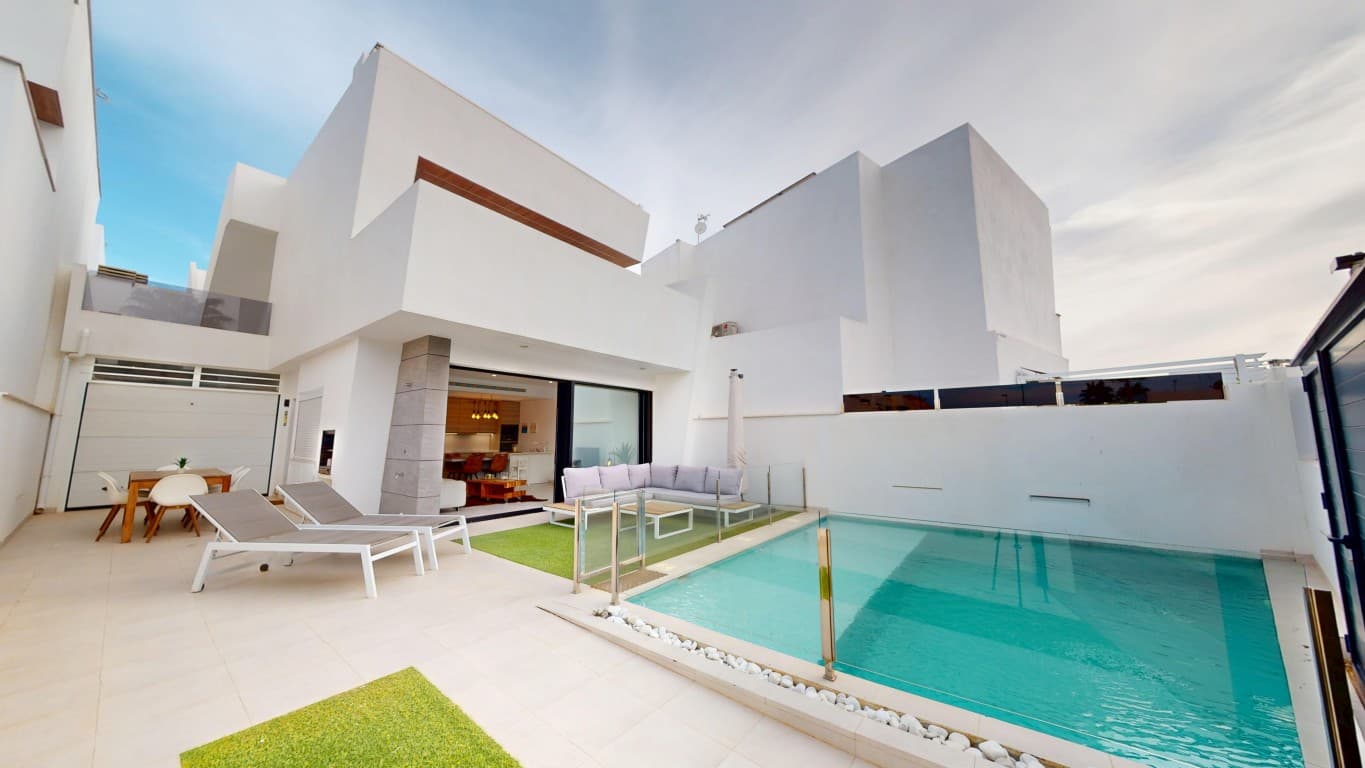 Discover this beautiful, modern villa in Santiago de la Ribera, just 800 meters from the beach. Built in 2019 with comfort and style in mind, this home offers everything you need for permanent living or a luxurious holiday retreat.The villa features three spacious bedrooms and three modern bathrooms, and is being sold partially furnished. On the ground floor, you'll find an open-plan kitchen that flows seamlessly into the dining and living area. Large sliding windows fill the space with natural light and provide direct access to the outdoor area, where a generous private swimming pool and an outdoor kitchen await.Also on the ground floor is a bedroom and bathroom, perfect for guests or for those who prefer single-level living. Upstairs, there are two additional bedrooms, each with direct access to a private terrace. The master bedroom includes an en-suite bathroom and a stylish walk-in wardrobe.A fixed staircase leads to the spacious solarium, where you can soak up the sun all day long while enjoying peaceful surroundings. The property is equipped with hot and cold air conditioning throughout and also includes a large garage.Don’t miss this opportunity to own a move-in-ready villa in a prime location on the Costa Cálida. Contact us today to arrange a viewing — we’d be happy to show you around.
