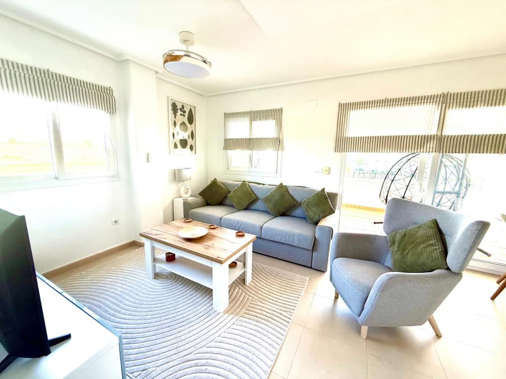 Vi er glade for å kunne presentere denne vakkert oppgraderte, ettertraktede leiligheten i første etasje med buede vegger og utsikt over basseng, golfbane og fjell. Leiligheten ligger i det inngjerdede boligområdet Hacienda Riquelme golfresort med 24-timers sikkerhet, 19 fellesbassenger, bare noen få minutters gange fra supermarkedet og baren/restauranten på stedet, og bare noen få minutters kjøretur fra den lokale byen Sucina med mange fasiliteter og barer/restauranter. Ideell beliggenhet for å utforske alt Costa Calida har å tilby.Når du kommer inn i denne fantastiske lyse endeleiligheten, kan du se at eierne har brukt mye tid på å gjøre den om til et nydelig feriehus.Det store, fullt utstyrte kjøkkenet har et vindu med romerske persienner med utsikt over fellesbassenget, oppgradert ekstra lagringsplass og hyller, gasskjel og hvitevarer, nøkkelklart og klart til innflytting.Den romslige stuen/spisestuen har et ekstra vindu som oversvømmer rommet med lys, med fantastisk panoramautsikt, smakfullt innredet med moderne møbler, klimaanlegg, radiator og vakre kontrasterende romerske persienner på alle vinduer. De doble skyvedørene fører ut til den overbygde store terrassen som er omgjort til et ekstra oppholdsrom med glassgardiner med persienner og fantastisk utsikt over svømmebassenget, golfbanen og fjellene. Et ideelt sted å underholde gjester, eller sitte og ha en cafe con leche mens man nyter den vakre utsikten.Badet med vindu er totalrenovert til høy standard med dusjkabinett, regndusjhode, nisje for toalettartikler og helflislagt med en moderne vegg. Moderne servantskap med dobbel skuffe, servant og kran, speil, svart håndkletørker, spotlights, toalett og ekstra stort servantskap med to skuffer, marmorplate og speil over, perfekt for oppbevaring.Begge de lyse doble soverommene har god størrelse og har innebygde skyvedører i garderober, takvifte, radiator og terrassedører som begge åpner ut mot en flislagt balkong med oppgraderte glassgardiner og vinduer. Det er et fantastisk sted å sitte og lese en bok mens man nyter den fantastiske utsikten.Privat underjordisk parkeringsplass med fjernkontroll og heis.Murcia internasjonale lufthavn ligger bare 18 minutters kjøretur unna.De gylne strendene i Mar Menor ligger bare en 15-minutters kjøretur unna.Denne leiligheten er nøkkelklar og visning anbefales på det sterkeste, og selges hovedsakelig møblert.