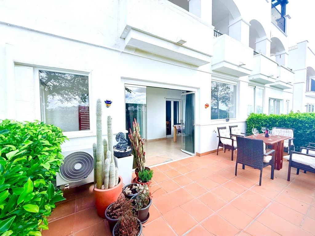 South West facing frontline Golf Apartment. South-West Facing Frontline Golf Ground Floor Apartment with Stunning ViewsThis beautifully presented south-west facing frontline golf ground floor apartment enjoys fantastic open views across the golf course and is ideally located within easy walking distance of the resort’s amenities, including the coffee shop, supermarket, and restaurant.The property features a fully upgraded and well-equipped kitchen, with a glazed door leading to a separate utility room which houses a new gas boiler.A bright entrance hallway leads into a spacious, light-filled lounge, complete with air conditioning and large patio doors that open onto a generous glazed terrace. This wonderful space offers plenty of room for seating and relaxation while enjoying the stunning golf course views. The glazed panels can be fully opened during the warmer months, seamlessly connecting the space to a south-west facing fully tiled open terrace with a privacy hedge — ideal for sunbathing, entertaining, or enjoying alfresco dining while taking in the beautiful surroundings.The master bedroom overlooks the attractive communal area and benefits from a double storage bed, fitted sliding wardrobes, additional storage, roller shutter blind, ceiling fan with light, and radiator.The second bedroom is currently used as a dining area and also features fitted sliding wardrobes, additional storage and patio doors leading out into the covered glazed terrace area. This room can easily be returned to a comfortable guest bedroom if desired.The fully tiled bathroom includes a bath with overhead shower and glass screen, an upgraded vanity unit with basin and mirror, a new heated towel radiator, WC, and a tall mirrored storage unit.Additional features include a private designated underground parking space, accessed by remote control, with elevator access to the apartment level.Residents of the resort enjoy 24-hour security and access to 19 beautifully maintained communal swimming pools set within landscaped gardens.The apartment is located just 5 minutes from the charming village of Sucina, where you will find a great selection of bars, restaurants, supermarkets, and everyday amenities. The location is also perfect for exploring the beautiful Costa Cálida, with its stunning beaches, golf courses, marinas, and traditional Spanish towns.This is a fantastic opportunity for a holiday home, rental investment, or permanent residence in a superb golf resort setting.