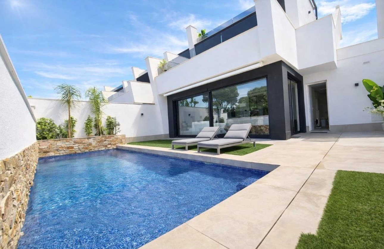 Looking for a modern new build, but do not want to wait for it to be built? Look no further as we are excited to list this stunning RESALE three bedroom four bathroom detached villa with pool and garage.  Located just 950m from the beach in Santiago de la Ribera with all the amenities you could need just walking distance, public transport links with buses going to various locations including Murcia, Cartagena, Cabo de palos and Campoamor. There is also a ferry service over to La Manga Strip.On entering this stylish villa there is a hallway with a useful wardrobe which leads through to the open plan kitchen with an island and then through to the lounge which has large patio doors that open to the west facing garden which has a terraced area and a 28m2 heated pool. On this level is a double bedroom with walk through wardrobe and en suite bathroom and there is also a separate WC. Upstairs are two further double bedrooms also with walk through wardrobes and ensuites and both have patio doors to the first floor terrace which has stairs leading to the large roof solarium which has a summer kitchen and all day sun. This property has an integrated garage which has a door to the villa and a door to the garden. The property comes furnished, vented AC, anti solar glare glazing, automated mosquito blinds, and electric awnings. Do not hesitate to contact us to arrange to view this stunning villa.