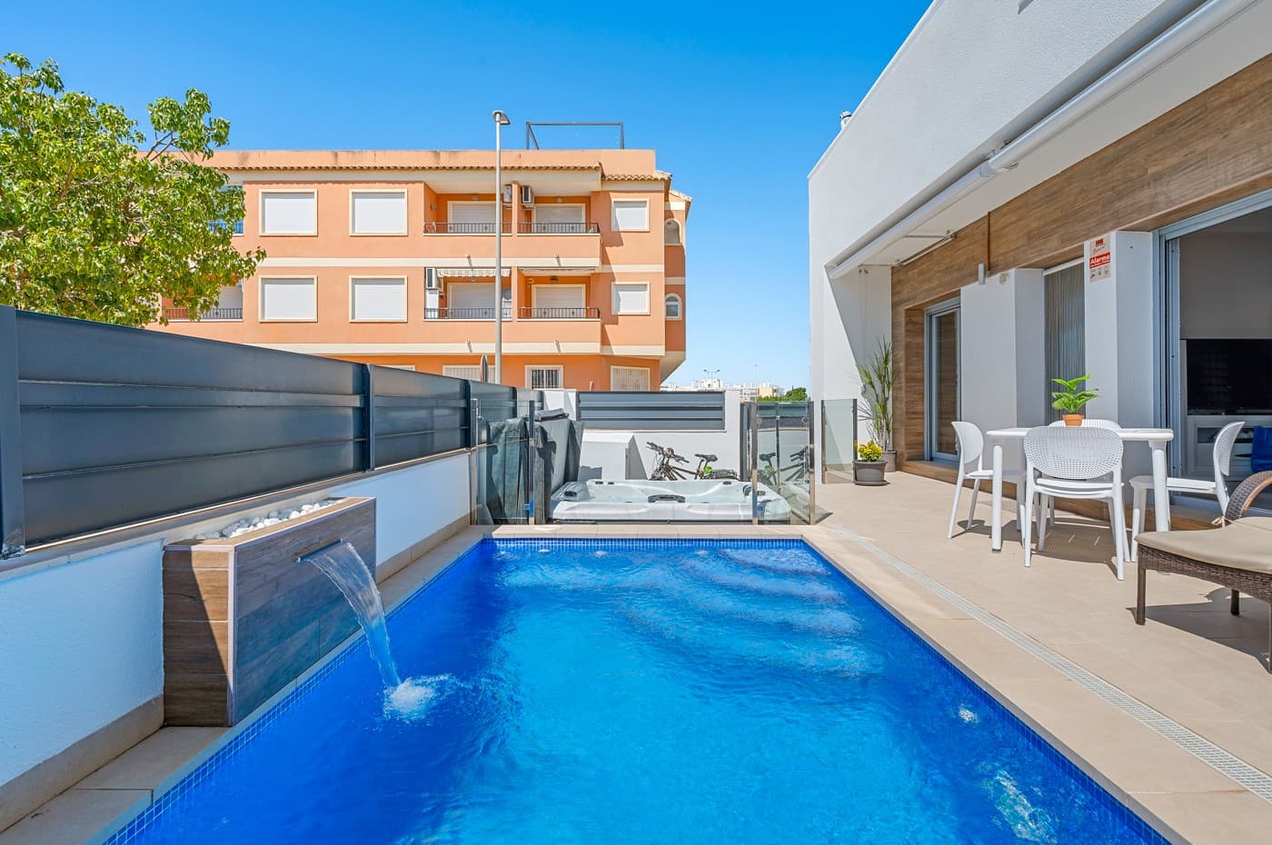 Located in the heart of the charming and authentic Spanish village of Formentera del Segura, this beautifully maintained townhouse offers a unique combination of modern comfort and traditional atmosphere. Built in 2018, the home is part of a small and exclusive community of only four properties. All current neighbours have owned their homes since the development was completed. This is the very first time one of these properties is being offered for sale, making it a rare and valuable opportunity.

The property features three spacious bedrooms and two stylish bathrooms, one of which is en-suite. Two of the bedrooms are conveniently located on the ground floor, making the home practical and easy to live in year-round. The interior is tastefully decorated with high-quality furniture and finishes, all of which are included in the sale. The house has been meticulously cared for and is in excellent condition, offering a true turn-key solution.

Outside, you are welcomed by a private swimming pool with a beautiful waterfall feature, as well as a private jacuzzi – the perfect spot for relaxation and enjoyment. The rooftop terrace offers wonderful potential: it has already been prepared for the extension of the third bedroom with one more private bathroom, with both drainage and electrical installations prepared. The terrace is ideal for entertaining or simply enjoying the Mediterranean lifestyle, complete with built-in sunshades, privacy screens, and a sheltered lounge area. The views from here are truly amazing!

The home is equipped with a full-house water filtration system, allowing you to drink directly from the tap. There is air conditioning on both levels – a central system downstairs and a separate unit upstairs – as well as ventilation that has ensured no moisture issues, even when the house has been unoccupied for a long time. Fibre internet is installed and reinforced to provide strong coverage even on the rooftop terrace, making it suitable for working remotely or streaming under the sun also from the rooftop terrace!

This lovely home is sold fully furnished. 

Formentera del Segura offers a welcoming, international community while maintaining its traditional Spanish soul. You’ll find local cafés, bakeries, and restaurants just a short walk away, nearest supermarket is just a two minutes walk! The Norwegian school is an 8-minute drive away. And the golden beaches of Guardamar del Segura only ten minutes by car. Several excellent golf courses are nearby, along with scenic cycling routes and natural parks. This is a truly special home in an exceptional location – perfect for those seeking comfort, style, and a peaceful way of life on the Costa Blanca.