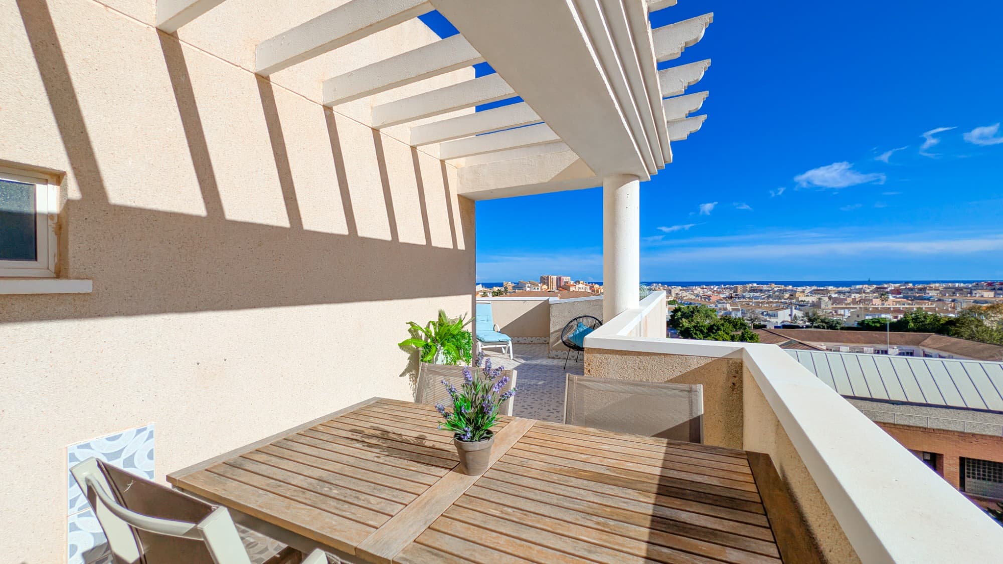 In Nueva Torrevieja, you will find this penthouse with views over the city of Torrevieja and the sea in the distance. With three bedrooms, it is a true gem at the top of the building, featuring a large private terrace on the same floor where you can sunbathe, enjoy meals, watch the sunrise over the sea, or simply spend time with family and friends. The terrace faces southeast, making it ideal for year-round living. During warm periods, you can use the outdoor shower on the terrace to cool off. On the south side, there is a smaller balcony where you can enjoy your afternoon coffee.From the entrance, you reach the heart of the apartment: the open-plan living room and kitchen, which also have direct access to the large terrace. With three spacious bedrooms, two of them with built-in wardrobes, the apartment is an excellent investment for a larger family, either as a permanent home or as a holiday property.Two bedrooms have space for large double beds; the third, smaller room can easily fit a bunk bed or a large single bed. One of the master bedrooms has direct access to the large terrace; the second has direct access to the smaller south-facing balcony. The third bedroom offers the sunset right outside the window with an unobstructed view over the city.Adjacent to the master bedroom is an en-suite bathroom with washing machine, shower and WC, renovated in 2020. The other bedrooms are located next to a second bathroom in good condition, with a bathtub and WC.The kitchen was renovated in 2021 and is equipped with a dishwasher and all conveniences. The large archway connects directly to the living room, with large doors leading out to the terrace.The apartment is sold furnished, including all kitchenware, beds, TV, outdoor furniture, etc.Adjacent to the building, there is an option to purchase a private, covered parking space located in a separate parking area. The parking space has its own property registration and title deed, and can therefore be sold separately. The price of the apartment does not include the parking space; it is sold separately for €10,000. The community also has a shared pool and a playground for younger children.The location of the apartment means that restaurants, shopping and services are all in the same block, yet the apartment is still situated in a peaceful and quiet area where you can sleep safely. Across the street is a health centre, and within a 15-minute walk you reach the sea and Torrevieja’s famous promenade, with beaches where you can swim in some of Spain’s cleanest waters.Warm welcome to a fantastic property with wide views and generous spaces!