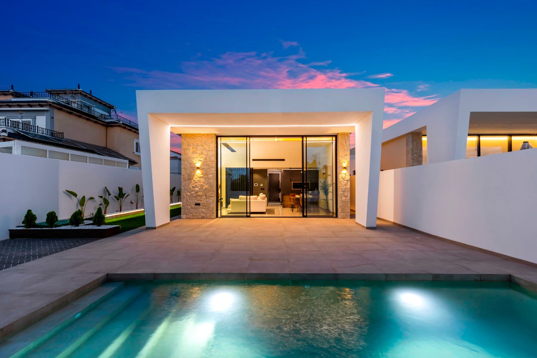 Discover the life you've always dreamed of in this exclusive new construction project that redefines the concept of functional luxury in the prestigious Torreta Florida Urbanization in Torrevieja. These villas have been designed with quality of life in mind, combining an unbeatable location with cutting-edge architectural design and a profound respect for natural light.

A Design that Connects with Nature and Light

Each villa is a haven of serenity. With a construction of 145 m² on plots of 400 m², these homes offer a modern, open-concept layout. The renders show a bright and spacious interior, where the living room, dining room, and kitchen merge into a single fluid space. The minimalist aesthetic, with straight lines and a neutral color palette, creates an atmosphere of calm and sophistication. The porcelain tile floors and large windows not only provide elegance but also maximize the entry of light, turning every corner into a vibrant space.

The exterior of the villa is a true private oasis. Imagine enjoying a spacious garden with lawn, palm trees, and a refreshing private pool (optional) where you can relax and sunbathe. The 60 m² rooftop solarium offers an intimate space with clear views, ideal for moments of peace or for socializing under the Mediterranean sky.

Quality and Personalization in Every Detail

In these homes, quality is a priority. The properties include high-end standard equipment, such as thermal and acoustic insulation, Technal windows with thermal break and electric shutters, an armored door, and radiant floor heating in the bathrooms.

Additionally, the project offers a range of customization options to make your home unique. From the integration of BOSCH appliances and smart lighting to the installation of solar panels or a saltwater pool. The detailed plans also show the possibility of a 60 m² basement with various configurations, which can be transformed into a gym, a home theater, or a workspace.

A Strategic Location for a Full Life

Located just 5 minutes from the center of Torrevieja, these exclusive villas offer the tranquility of a residential urbanization without giving up the convenience of having everything within reach. The area is surrounded by services, supermarkets, health centers, and parks. Furthermore, it is close to the most famous beaches in the region and at an ideal distance from prestigious golf courses.

These villas are more than a house; they are an investment in a lifestyle of luxury and comfort. Contact us for more information on prices and the availability of the SUNRISE plots.







