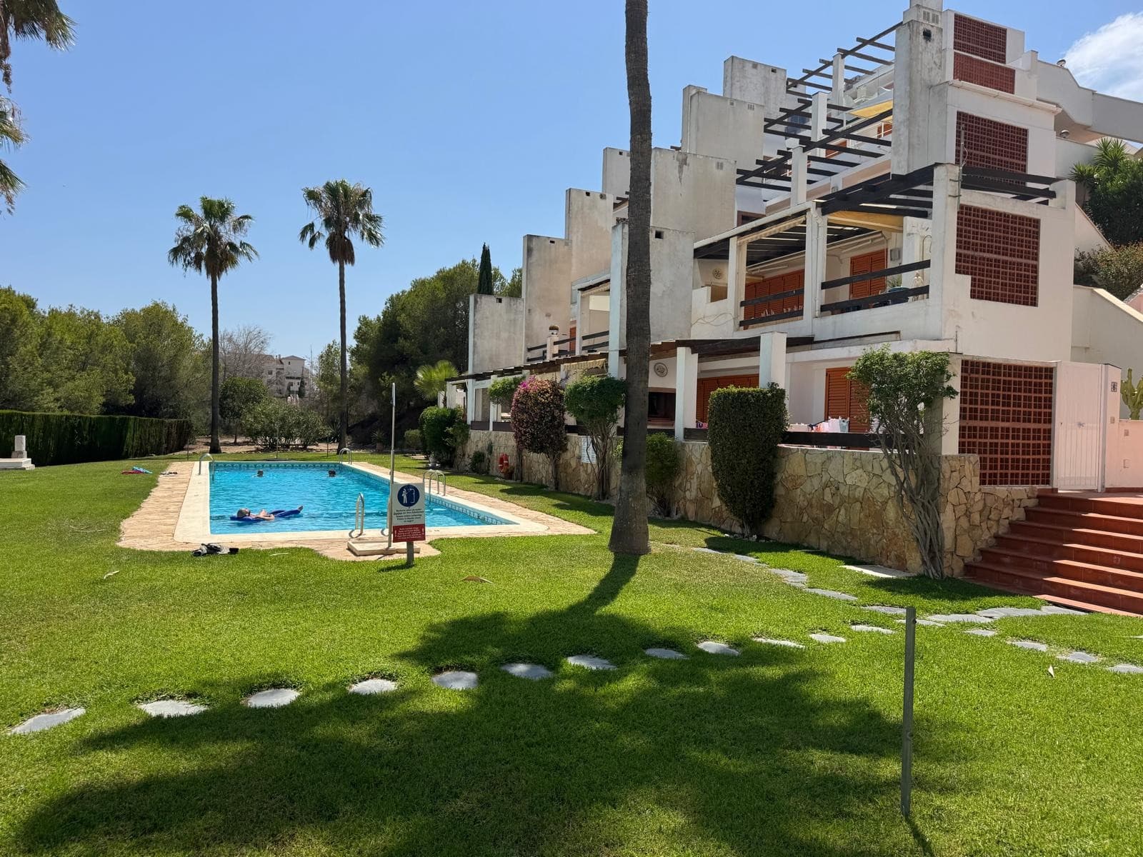 This beautifully maintained Claveles-style apartment is presented in immaculate condition and offers generous indoor and outdoor living spaces. Boasting a large, full-length terrace with uninterrupted views across the prestigious Las Ramblas golf course, this property is perfect for enjoying the Spanish sunshine and tranquil surroundings.

The spacious living area seamlessly flows out onto the terrace, effectively extending your living space and providing an ideal setting for relaxing or entertaining. Inside, you’ll find a well-appointed open-plan kitchen with ample worktop space, a raised dining area, and a welcoming ambiance throughout.

Accommodation includes:





Three bedrooms – one with a walk-in wardrobe, one en-suite, and one positioned at the opposite end of the apartment for added privacy.





Two bathrooms – including a family-sized bathroom and a private en-suite.





Double-length garage and a dedicated golf buggy parking space.





Located in the sought-after Las Ramblas Golf Urbanization, this apartment is within easy walking distance to the clubhouse and driving range. Just a short drive away is the vibrant La Fuente Commercial Centre, offering a wide range of amenities including restaurants, bars, and a pharmacy. The stunning sandy beaches of Orihuela Costa are also just a few minutes away.

Whether you’re seeking a permanent home, holiday getaway, or a sound investment in a prime location, this exceptional apartment ticks all the boxes.



Basic Features





Built area: 100 m²





Usable area: 90 m²





Bedrooms: 3





Bathrooms: 2





Terrace: Spacious, full-length terrace with golf course views





Garage: Double-length private garage included





Condition: Second-hand, very well maintained





Storage room: Included





Orientation: East-facing





Built-in wardrobes: Yes





Year built: 2003





Heating: Individual hot/cold air pump system





Building





Location: Exterior-facing





Floor level: Ground-level access



Equipment & Amenities





Air conditioning: Installed





Swimming pool: Communal pool access





Energy certificate: In process







