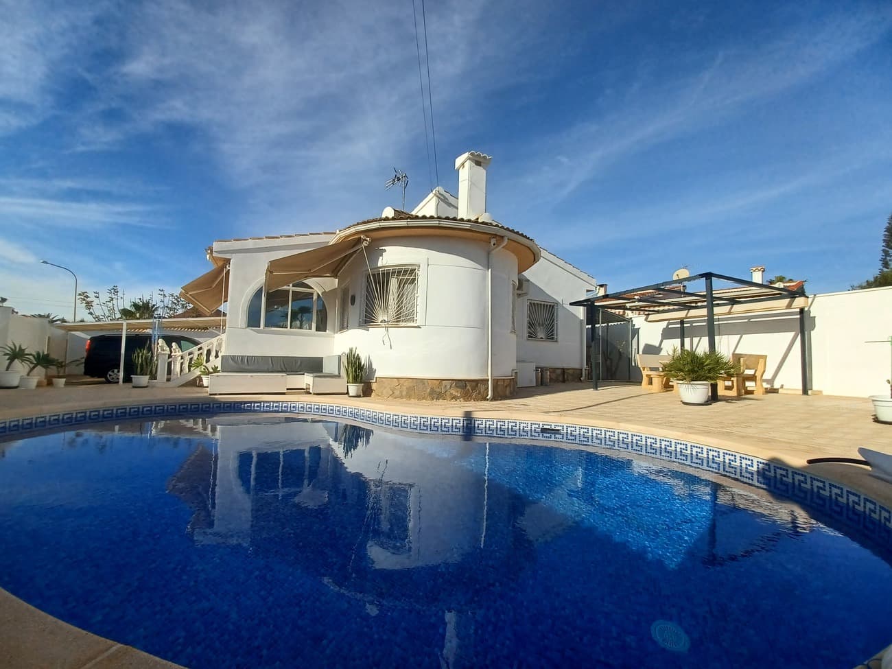 This beautiful detached villa with swimming pool really has it all, it is a large corner plot of  with plenty of sunshine all day long and comes with airconditioning and oil central heating,  The villa enters into an enclosed glassed in area ideal for enjoying winter sun and dining.  The terrace leads to the living room, it is open plan kitchen and living room with curved wall feature and windows overlooking the terraces and pool, with air-conditioning currently furnished with sofa, coffee table and unit.  The kitchen is modern and comes with fitted kitchen cupboards, granite worktop, fridge freezer, hob, oven and canopy. The kitchen leads to a pantry which is a good size and could be integrated into the kitchen, this pantry offers plenty of storage.  The pantry leads to a large garage, it is currently being used for storage and has plenty of storage cupboards.  The living room leads to a hallway leading to 2 bedrooms and to a bathroom.  The main bedroom is spacious and is furnished with a double bed, bedside tables and fitted wardrobes with air-conditioning.  The bathroom is situated between the 2 bedrooms, it comes with a shower, vanity unit and wc.  The second bedroom is a smaller double room, currently being used as a dressing room.  There is a third bedroom upstairs, the stairwell leads from the front of the house to the third bedroom with en-suite bathroom; this bedroom is very spacious with light coming in from both sides currently furnished with double bed, bedside cabinets and air conditioning.   The bathroom has a shower, wc, vanity unit and window.  The garage which leads to the kitchen and living area  is very large and is suitable to create a 4th bedroom.  The property comes with plenty of outdoor storage at the rear of the property and there is a large cage enclosure currently used for a pet cat and can be kept for pets or removed.  The plot comes fully tiled with concrete non slip tiles, stone dining table and benches with awning for alfresco dining, a covered carport and outdoor shower.  There is a 3rd bathroom at the back of the house ideal for pool and outdoor living.  There is mosquito nets on all of the windows and many extras.  The plot is surrounded by high walls for privacy and it has a peidestrian gate and a gate for the carport.  Situated in the highly sought after area of Quesada in a quiet residential area, close to the beaches of Guardamar and the coastal town of Torrevieja.  This villa is well maintained and highly recommended for viewing.