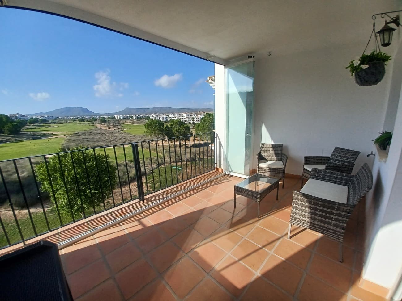 A unique and beautiful corner apartment situated in a sought after building at the end of the golf course; it is light, bright and airy;  with the most stunning views the length of the golf course with the mountains in the distance and the swimming pool to the side   The apartment  enters into a spacious living/dining room well furnished with air conditioning,  sofa, dining table and chairs, units and TV with patio doors and windows allowing plenty of natural light and views.  The living room leads to a spacious terrace, it is a west facing covered terrace with  plenty of space for outdoor living and dining and enjoying the sunshine.  The living room leads to a hallway; to the left is the kitchen, with a fitted kitchen and well equipped with high quality electro domestics; ceramic hob, oven and canopy; washing machine, fridge & freezer.  The bathroom is very spacious and it has been upgraded, it has a large walk in shower, vanity unit, wc and bidet and it comes with an arched window.  There are two double bedrooms at the rear of the apartment, both come with patio doors leading to a balcony and views over the gardens to enjoy morning sun.  Both bedrooms are with fitted wardrobes, double beds and bedside cabinets and ceiling fans.  The apartment comes with lift and underground parking space and this apartment is close to a pool.  Situated in Hacienda Riquelme Golf Resort the community includes 24 hour security, gardens, 19 pools, sports facilities, WIFI & satellite tv offering high standard living.  This apartment is highly recommended for viewing.