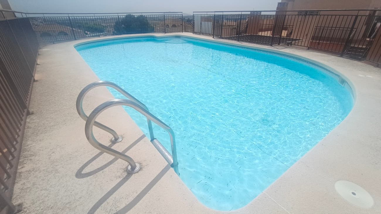 This light, bright, and airy apartment in Sucina offers spacious and comfortable living in a well-maintained, centrally located building with lifts and a rooftop swimming pool.Upon entering, you are welcomed by a wide entrance hallway, ideal as a reception area, which leads into a central corridor connecting the rest of the home.To the right, you’ll find the main bathroom, complete with a bathtub and shower, WC, and sink.To the left, the living room is a standout feature—generously sized with floor-to-ceiling windows on both sides, allowing natural light to flood the space throughout the day. With its southwest orientation, the room enjoys sunshine from morning through evening. The windows are fitted with railings, creating a pleasant spot to sit, relax, and soak up the light.Further along the corridor on the left is the fully fitted kitchen, offering ample space, worktops, and included appliances—ideal for both everyday living and entertaining.Next is a spacious double bedroom with built-in wardrobes, providing practical storage and comfort.At the end of the corridor is the master bedroom, a bright and airy space featuring floor-to-ceiling windows on both sides, allowing for excellent natural ventilation and light. It comfortably accommodates a double bed and creates a peaceful retreat.The building itself is clean, well cared for, it comes with fully integrated air conditioning and ideally located close to all local amenities. With both lift and stair access, as well as a rooftop swimming pool, it offers convenience and lifestyle in equal measure.