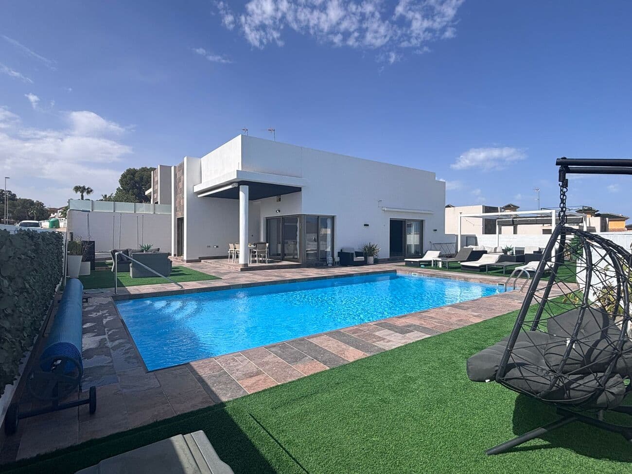 Elegant Mediterranean Living in Pau 8, VillamartínSet within one of the most desirable residential enclaves on the southern Costa Blanca, this beautifully presented Innova-style villa in Pau 8, Villamartín offers a compelling blend of modern comfort, flexible living, and timeless Mediterranean appeal. Located near Villamartín, and within easy reach of Orihuela Costa, the property delivers an enviable lifestyle in a setting that continues to attract discerning buyers from across Europe.This is more than just a home—it is an opportunity to embrace sunshine, space, and a relaxed yet vibrant way of life in one of Spain’s most sought-after coastal regions.A Prime Location in a Sought-After Residential CommunityThe community of Pau 8 is widely regarded as one of the most attractive and well-maintained areas in Villamartín. Known for its peaceful atmosphere, beautifully kept surroundings, and charming villas, it offers a sense of tranquility while still being close to everything you need.Just a short walk away lies the ever-popular Villamartin Plaza, a lively social hub filled with restaurants, cafés, bars, and boutique shops. Whether you’re enjoying a morning coffee, a leisurely lunch, or an evening out with friends, the plaza provides a welcoming and vibrant setting all year round.This balance between peaceful residential living and nearby social energy is one of the defining features that makes this location so appealing.A Villa Designed for Modern Comfort and StyleFrom the moment you enter the property, the sense of quality and thoughtful design is immediately apparent. The villa has been finished to a high standard, with bright and airy interiors that maximise natural light and create a seamless flow between living spaces.Clean lines and contemporary finishes combine with practical design elements to create a home that is both stylish and functional. Every detail has been considered to ensure comfort, ease of living, and long-term durability.The main living areas are welcoming and versatile, ideal for both relaxing in privacy and entertaining guests. Large windows and open-plan elements enhance the feeling of space, while maintaining a warm and inviting atmosphere.A Unique Lower Level: Flexible Living at Its BestOne of the most impressive features of this villa is its fully reformed lower level, designed as a completely self-contained living space.This area includes two spacious bedrooms, a comfortable lounge or entertainment room, an office space perfect for remote working, and a fully equipped independent kitchen. The layout offers exceptional flexibility, making it ideal for a variety of uses.Whether you wish to host visiting family and friends, provide independent accommodation for extended family members, or generate rental income, this level allows you to do so while maintaining privacy in the main living areas.In today’s market, where flexibility and multi-functional living spaces are highly valued, this feature significantly enhances both the lifestyle and investment appeal of the property.Thoughtfully Designed for Family LivingThroughout the villa, there is a clear emphasis on creating a home that supports both everyday living and special moments.The layout provides a perfect balance between private spaces and communal areas, allowing each member of the household to enjoy their own retreat while still coming together for shared experiences. High-quality finishes ensure that the property is not only visually appealing but also practical and easy to maintain.This is a home designed to adapt—whether you are living here full-time, using it as a holiday retreat, or combining personal use with rental opportunities.Outdoor Living: Embracing the Mediterranean LifestyleOutdoor space is at the heart of life on the Costa Blanca, and this villa has been designed to make the most of it.The property features generous exterior areas that allow you to fully embrace the region’s exceptional climate. With over 300 days of sunshine each year, outdoor living becomes an integral part of daily life.A heated private swimming pool provides year-round enjoyment, offering the perfect setting for both relaxation and recreation. Whether it’s an early morning swim or an evening dip under the stars, the pool adds a touch of luxury to everyday living.A dedicated outdoor dining area creates the ideal space for al fresco meals, entertaining guests, or simply enjoying the warm Mediterranean evenings. The surrounding areas offer ample room for sunbathing, gardening, or creating your own private oasis.A Stunning Private Solarium with Endless PotentialOne of the standout highlights of this property is the spacious private solarium.This elevated rooftop space offers open views and all-day sunshine, making it a true extension of the living area. It provides a peaceful retreat where you can unwind, soak up the sun, or enjoy panoramic surroundings.The solarium also offers excellent potential for further enhancement. There is ample space to install a fully equipped outdoor kitchen, along with a stylish dining and entertainment area. This opens the door to creating a bespoke rooftop lifestyle space—perfect for hosting barbecues, evening gatherings, or relaxed sunset dinners.Few features capture the essence of Mediterranean living quite like a well-designed rooftop terrace, and this one offers both beauty and versatility.Close to Some of the Costa Blanca’s Best BeachesThe location of this villa places you within easy reach of some of the most beautiful beaches in the region.Among them is Playa de la Zenia, renowned for its golden sands and crystal-clear waters. Whether you’re looking to swim, sunbathe, or enjoy beachfront dining, this beach offers the perfect coastal escape.The surrounding coastline is dotted with equally आकर्षive beaches and coves, ensuring you always have somewhere new to explore.A Paradise for Golf EnthusiastsFor those who enjoy golf, this area is nothing short of exceptional.The villa is located close to Villamartín Golf Club, one of the most renowned courses in the region. Known for its सुंदर layout and चुनौतीपूर्ण design, it attracts players of all levels.In addition, several other high-quality golf courses are located nearby, making this area a true haven for enthusiasts. The ability to enjoy world-class golfing just minutes from your home is a significant advantage.Shopping, Dining, and Entertainment at Your FingertipsConvenience is another key benefit of this property’s location.The impressive Zenia Boulevard Shopping Centre is just a short drive away, offering a wide selection of international brands, restaurants, and entertainment options. From everyday essentials to leisure activities, everything you need is within easy reach.Local amenities, including supermarkets, healthcare facilities, and schools, further enhance the practicality of living in this area.The Appeal of Orihuela CostaThe wider region of Orihuela Costa continues to be one of the most popular destinations for property buyers in Spain.With its combination of excellent infrastructure, stunning coastline, and vibrant yet relaxed lifestyle, it offers something for everyone. The area enjoys a welcoming international community while retaining its authentic Spanish charm.The climate is another major draw, with over 300 days of sunshine each year creating ideal conditions for outdoor living and year-round enjoyment.Versatility for Every Type of BuyerThis property is ideally suited to a wide range of buyers.For those seeking a permanent residence, it offers comfort, space, and a fantastic location. As a holiday home, it provides the perfect escape with excellent amenities nearby. For investors, the combination of location, layout, and rental potential makes it an attractive proposition.Few properties manage to cater so effectively to such a broad audience.Experience the Best of Mediterranean LivingUltimately, this villa is about more than just its features—it’s about the lifestyle it enables.Imagine waking up to sunshine, spending your days exploring beaches and golf courses, and your evenings enjoying great food and company in a warm, welcoming environment. This is the essence of life on the Costa Blanca.With its elegant design, flexible living spaces, and unbeatable location near Villamartín, this property offers a rare opportunity to enjoy all of this and more.A Property That Truly Stands OutIn a market filled with options, properties that combine quality, location, and versatility are increasingly rare.This Innova-style villa in Pau 8 stands out for all the right reasons. From its beautifully finished interiors to its exceptional outdoor spaces and prime location, it delivers on every level.For those looking to secure a home in one of Spain’s most desirable coastal regions, this is an opportunity not to be missed.Stylish Mediterranean Villa in Pau 8, VillamartínLocated in one of the most desirable residential areas on the southern Costa Blanca, this beautifully presented Innova-style villa in Pau 8, Villamartín offers a superb combination of modern design, flexible living, and Mediterranean charm. Set within the popular area of Orihuela Costa, this home is ideal for permanent living, a holiday retreat, or a smart investment opportunity.Bright, Modern Interiors Designed for ComfortThe villa has been finished to a high standard, featuring bright and airy interiors that maximise natural light. The layout has been carefully designed to create a seamless flow between living spaces, offering both comfort and style.The main living areas are spacious and welcoming, ideal for everyday living or entertaining guests. Clean lines and quality finishes give the home a contemporary feel while remaining warm and practical.Self-Contained Lower Level for Added FlexibilityA standout feature of this property is its fully reformed lower level, designed as a self-contained living space.This area includes two spacious bedrooms, a comfortable lounge or entertainment space, an office ideal for remote working, and a fully equipped independent kitchen. It’s perfect for hosting guests, accommodating extended family, or generating rental income while maintaining privacy in the main home.This flexibility significantly enhances both the lifestyle appeal and investment potential of the property.Outdoor Living at Its FinestDesigned to take full advantage of the Costa Blanca climate, the villa offers generous outdoor spaces perfect for relaxing and entertaining.A heated private swimming pool allows for year-round enjoyment, whether you prefer a refreshing morning swim or a relaxing evening dip. There is also a dedicated outdoor dining area, ideal for al fresco meals and social gatherings.The surrounding space offers plenty of room for sunbathing, gardening, or simply unwinding in a peaceful setting.Private Solarium with Incredible PotentialThe spacious private solarium is another highlight of this home. This rooftop space provides open views and all-day sunshine, creating a perfect retreat.There is also excellent potential to add an outdoor kitchen and dining area, transforming it into a stylish entertainment space ideal for barbecues, sunset dinners, and relaxed evenings with family and friends.Close to Beaches, Golf, and AmenitiesThe location of this villa puts you within easy reach of some of the best attractions in the area.The beautiful Playa de la Zenia is just a short drive away, offering golden sands and clear waters perfect for relaxing or swimming.Golf enthusiasts will appreciate the proximity to Villamartín Golf Club, as well as several other top-quality courses nearby.For shopping and entertainment, the popular Zenia Boulevard Shopping Centre provides a wide range of shops, restaurants, and leisure options.The Perfect Costa Blanca LifestyleWith over 300 days of sunshine each year, excellent infrastructure, and a welcoming international community, Orihuela Costa remains one of Spain’s most popular destinations.This villa combines quality design, flexible living space, and an unbeatable location, offering a fantastic opportunity to enjoy the very best of Mediterranean living.