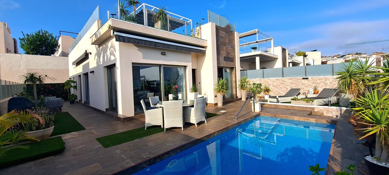 This stunning 4-bedroom Innova villa is situated in one of Villamartin's most desirable areas, just a short drive from local shops, restaurants, and amenities. Designed for effortless single-level living, the home features a private swimming pool, off-road parking, and a generous L-shaped garden—perfect for outdoor relaxation or entertaining guests.Inside, you’ll find a bright and spacious open-plan living and dining area that flows into a sleek American-style kitchen complete with modern built-in appliances. A separate utility room adds extra convenience. The villa includes four well-proportioned bedrooms and 2.5 bathrooms, with the guest WC already pre-installed for an easy upgrade to a full third bathroom.Abundant natural light floods the home through large windows and high ceilings, while ducted hot and cold air conditioning ensures comfort throughout the year. Electric blinds are installed throughout for effortless light and privacy control.A standout feature is the expansive rooftop solarium, which spans the entire footprint of the villa. It includes a stylish bar area, electric awnings with integrated wind sensors, and contemporary glass balustrades—offering a private and luxurious space to relax or host gatherings under the sun.Ideally located just 1km from an ALDI supermarket and the Via Park commercial centre—with its array of bars and restaurants—the villa is also just a short drive to the popular Villamartin Plaza and golf course.Combining modern comfort, low-maintenance living, and Mediterranean style, this beautifully designed villa is a fantastic opportunity in a prime location.
