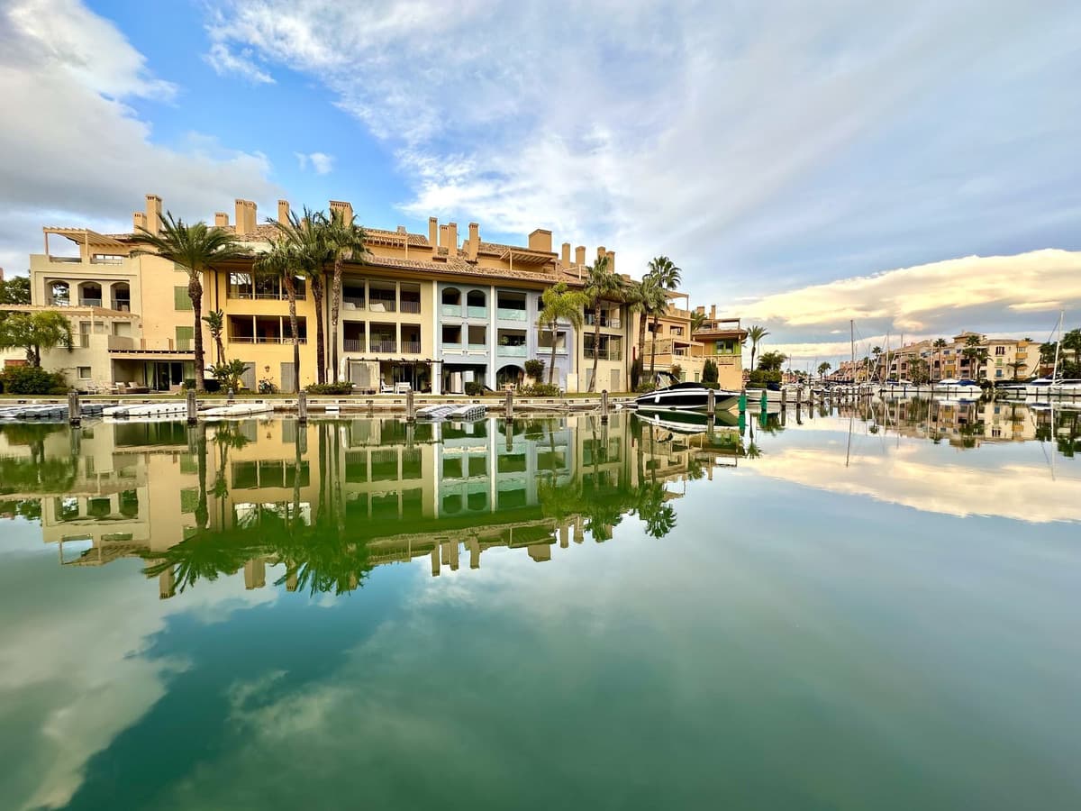 ¡Descubre tu oasis en la exclusiva Marina de Sotogrande! Este magnífico apartamento de 180 m² te ofrece la combinación perfecta de lujo y confort en un entorno tranquilo y sofisticado. Con tres amplios dormitorios, incluyendo una suite principal con baño privado, y un salón luminoso con chimenea, cada rincón está diseñado para tu bienestar. La espectacular terraza cubierta de 40 m² es el lugar ideal para disfrutar de las impresionantes vistas al canal mientras te relajas con una copa de vino. La cocina, completamente equipada, satisface todas tus necesidades culinarias, mientras que el sistema de climatización centralizado garantiza el confort durante todo el año. Además, cuentas con dos plazas de aparcamiento interior, perfectas para tu comodidad. A solo 5 minutos a pie del mar y del famoso Mercadillo de Sotogrande, estarás rodeado de playas, restaurantes y tiendas. La urbanización ofrece seguridad 24 horas, asegurando tranquilidad en todo momento. Para los amantes del deporte, la zona es un paraíso con opciones como deportes náuticos, polo y golf a poca distancia. El Real Club Sotogrande y el Ayala Polo Club están a un corto trayecto en coche. Construido en 2003 y en excelente estado, este apartamento es una joya en el sur de España. No pierdas la oportunidad de vivir en una de las áreas más exclusivas y deseadas. ¡Ven a visitarlo y enamórate de tu nuevo hogar!