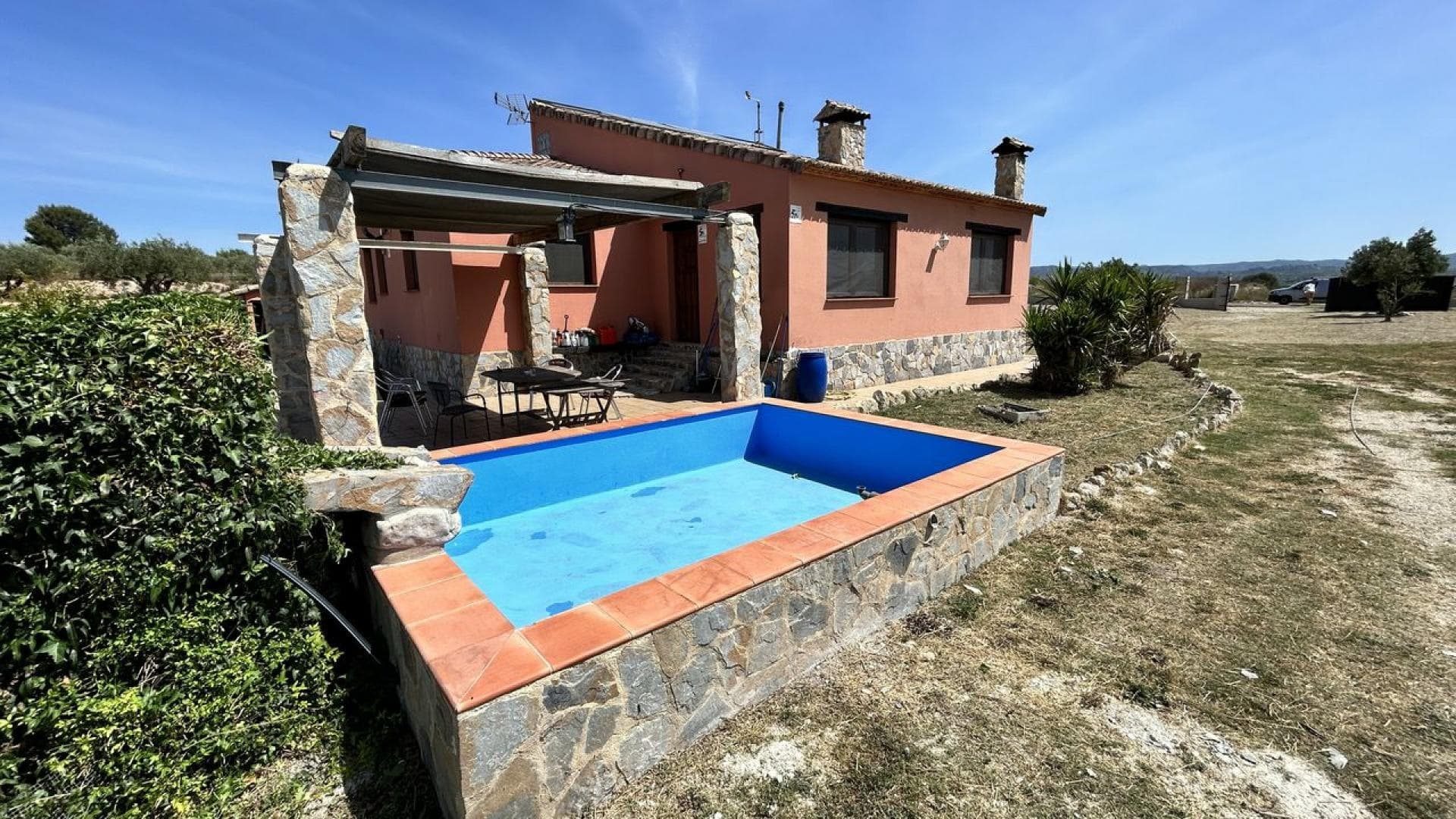 Chalet de Campo (280m2) con Nave Comercial adyacente (160m2) construido en un terreno de 12.957m2 (15,54 fanegadas) en el municipio de Benigánim!La construcción de este chalet ha sido aprobada y registrada por la autoridad de planificación urbana local. Está situado en una zona tranquila de belleza natural a las afueras de Benigánim. Situado en el centro de una parcela vallada con césped de 6.765 m², plantada con olivos centenarios y comunicada por caminos pavimentados hasta una puerta rodante de acero. A sólo 5 minutos en coche se llega al centro de la ciudad y a sólo 35 minutos en coche para disfrutar de las hermosas playas de arena de los populares centros turísticos cercanos de Oliva y Gandía. Esta propiedad está rodeada de campo abierto y virgen, pero a solo 20 minutos a pie se encuentra la estación de tren local que conecta con toda España. El lago de Bellús está cerca, lo que lo convierte en un sendero ideal para montar a caballo o simplemente pasear al perro, al que se accede directamente desde la puerta principal sin tener que cruzar carreteras transitadas. Totalmente legalizado y documentado, el Chalet fue construido en 2007 utilizando materiales térmicos de primera calidad, combinando la influencia mallorquina con elementos rústicos.Con una ubicación ideal, Benigánim es un municipio de la comarca de la Vall d'Albaida en la Comunidad Valenciana, situado entre los pueblos de Quatretonda y La Pobla del Duc. Tiene aproximadamente 6.000 habitantes, tiene un centro médico y buenas instalaciones comerciales, incluidos 3 supermercados de renombre y un mercado ecológico de frutas y verduras que se celebra una vez a la semana en la plaza del pueblo.Benigánim fue una histórica ciudad medieval de culto de la dinastía Borgia y está situada al sur de la provincia, a 80 kms. de Valencia. Está bien situado, a sólo 45 minutos del aeropuerto de Valencia y a poco más de una hora del aeropuerto de Alicante, comunicado por fácil acceso a la autopista cercana. La ciudad tiene una estación de tren y está a poca distancia del principal centro ferroviario de la cercana ciudad de Xátiva, que a su vez está unida a la red principal que sirve tanto de Valencia como de Madrid. La parcela del valle tiene un clima con temperaturas suaves durante todo el año, el valle es reconocido internacionalmente por el cultivo de frutos rojos, perfecto para disfrutar de sus múltiples actividades culturales, sus aclamadas fiestas, su hermoso centro histórico y su cálida gente.Esta muy espaciosa casa familiar se distribuye en una sola planta, sus 200m2 de superficie están divididos en estancias bien proporcionadas y es cálida en invierno y naturalmente fresca en verano debido a su gran volumen y distribución. Una característica destacada es el gran salón con su alto techo abovedado con vigas de Mallorca que crea una sensación relajada de espacio y aquí el suelo de baldosas de terracota ha sido decorado al azar con azulejos multicolores hechos a mano. Importada de Austria, esta gran estufa de leña de hierro fundido se ha instalado en una chimenea alta de piedra que actúa como punto focal. (Se ha previsto instalar un entrepiso de madera con escalera en caso de necesitar más espacio). Este salón está conectado a un gran comedor luminoso que disfruta de vistas panorámicas de 180º a las montañas y al cercano Parque Nacional y es un espacio ideal para entretener a los invitados con otra chimenea de leña como elemento de esquina, nuevamente empotrada en piedra natural similar.Desde el salón se accede a una gran cocina contigua, unida a través de un arco abierto realizado con piedra de la zona. Esta habitación tiene un techo decorativo con vigas de ladrillo arqueado de Mallorca y una superficie de trabajo en forma de L que ha sido cortada de una gran losa de exclusivo mármol italiano oscuro. Hay una unidad de almacenamiento en la isla para preparar alimentos o simplemente disfrutar de un desayuno comunitario sentado en taburetes; Existen conexiones de servicio para lavadora y lavavajillas junto con un fregadero doble frente a una ventana, abastecido con agua caliente desde una caldera de butano montada en la pared que también sirve a una cocina de gas empotrada.El dormitorio principal también tiene una estufa de leña con chimenea de piedra natural. Se incluye un bonito armario doble independiente de carpintería fabricado en nogal. Los otros dormitorios y baños están conectados a través de un pasillo largo y aireado y se accede a ellos a través de puertas de madera natural. El paso de paso está empotrado con chimenea de obra, preparada para quemador de pellet y se accede a través de un registro al sótano. Todo el Chalet tiene ventanas y puertas exteriores revestidas de pino, acristaladas con vidrio laminado “antirrobo” de 7 mm y sostenidas por vigas de traviesa de ferrocarril. Se utilizaron ladrillos con aislamiento térmico en todas partes, incluidas las paredes divisorias, lo que significa que el interior permanece fresco bajo el cálido sol del verano sin necesidad real de aire acondicionado y la misma construcción proporciona un buen aislamiento durante los pocos meses más fríos del invierno.Hay un gran baño que está equipado con un jacuzzi de diseño italiano con agua caliente conectada a otra caldera de gas montada en la pared. El segundo baño tiene plato de ducha de piedra decorativa y el agua caliente se suministra desde la misma caldera de butano independiente. El drenaje del edificio es a una fosa séptica remota autovaciable y ecológica. Se ha instalado un alto mástil metálico para una turbina eólica. La propiedad está conectada a la red de agua de la ciudad y cuenta con energía ecológica procedente de paneles fotovoltaicos montados en el tejado; ¡Así que no tendrás que pagar facturas de energía!La propiedad ofrece un sótano adicional de 80m2, con suelo de baldosas. El sótano alberga el inversor de paneles solares y las baterías y es fácilmente accesible a través de una puerta de garaje de más de 3 m de ancho. El espacio es perfecto para convertirlo en una fresca oficina subterránea, taller, gimnasio o dejarlo simplemente como espacio de estacionamiento en garaje para 2 autos.Un sendero de baldosas de hormigón facilita el mantenimiento de los desagües y recorre el edificio hasta el gran jardín, que se utiliza principalmente para cortar césped e incluye un aparcamiento de grava y acceso a la entrada cerrada por una pesada puerta metálica con ruedas. La puerta trasera del comedor conduce unos pocos escalones a un patio de azulejos con sombra con un estanque adyacente iluminado y una cascada, ideal para una barbacoa. Existe una conexión eléctrica monofásica independiente con un espacio adyacente embaldosado para que el comprador pueda instalar un gran jacuzzi para 6 personas en el futuro sin costes adicionales. Desde esta zona se pueden disfrutar de vistas panorámicas de este a oeste. Las montañas lejanas y el paisaje agrícola circundante son un lugar maravilloso e invitan a relajarse y disfrutar del entorno puramente mediterráneo. ¡Los cielos nocturnos oscuros y no contaminados brindan el mejor entretenimiento para contemplar las estrellas en esta idílica residencia familiar!Hay un almacén comercial adyacente de 160m2, ¡incluido en el precio de venta!Esta estructura ha sido aprobada y autorizada por la autoridad urbanística local. El almacén consta de una estructura alta de acero soldado de 160 m2 con paredes sólidas de ladrillo y ventanas con marcos metálicos protegidas por rejas de seguridad; El techo es de paneles sándwich de espuma metálica que reducen la temperatura térmica en verano y están aislados para retener la pérdida de calor en invierno. Se incluyen 4 paneles de techo de plástico transparente que brindan abundante luz natural. La estructura está conectada a la red de agua de la ciudad y cuenta con energía ecológica procedente de paneles fotovoltaicos montados en el techo; ¡Este almacén puede brindar al comprador una oportunidad ideal para iniciar un modelo de negocio económico desde casa!La entrada principal está asegurada por una puerta doble de acero y con un muelle de carga que proporciona un buen acceso para camiones pequeños. La entrada trasera está equipada con una puerta metálica de alta seguridad. Las amplias estanterías de almacenamiento metálicas aumentan el espacio disponible. Se incluyen 2 lámparas industriales suspendidas de tubos fluorescentes, antena de TV y chimenea para estufa de leña. El edificio dispone de una cabina de obra con inodoro, lavabo y ducha de agua caliente conectada a una caldera mural de gas butano. El drenaje es a una fosa séptica ecológica cercana. Hay un patio de hormigón con sombra en la parte trasera con un grifo exterior. Como alternativa a un proyecto comercial, el edificio se puede convertir en una casa unifamiliar legal de 3 dormitorios a muy bajo costo.El almacén de alta calidad tiene un gran potencial para diversas empresas comerciales y está situado a sólo 15 minutos de la red nacional de autopistas; Por ejemplo, almacenamiento y distribución de comercio online o, digamos, un hotel de vacaciones para perros, gatos y caballos. El almacén se presta particularmente para convertirlo en un establo para caballos con el centro ecuestre disfrutando de kilómetros de caminatas por el campo abierto y trotes junto al río en la puerta, literalmente sin caminos que cruzar. Sobre todo porque el edificio se encuentra en una parcela vallada de 1.581 m2 y ya cuenta con licencia para caballos. También hay un gallinero seguro cercado con cadenas incorporado al costado del almacén al que se accede para mantenimiento mediante puertas de acero. También se puede vallar el terreno de pastoreo situado frente al almacén. Actualmente se trata de un pasto abierto de 4.611 m2 con triple terraza y con suministro de agua potable. ¡Se podría construir una casa unifamiliar con impresionantes vistas en esta parcela sujeto a la aprobación del permiso de planificación!¡En la venta se INCLUIRÁ una parcela contigua de 4.611 m2 de buena tierra agrícola de “pasto”!