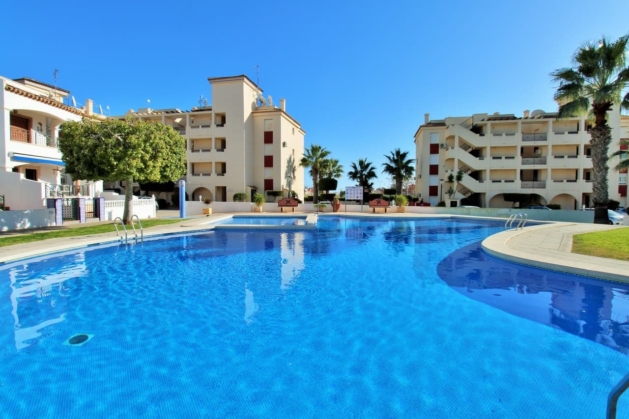 This spacious penthouse apartment is located within the sought after gated community of Jumilla III in Playa Flamenca, Orihuela Costa, Alicante. The apartment will be sold fully furnished and consists of a spacious living/dining room, a fully equipped kitchen, two double bedrooms with fitted wardrobes, two bathrooms (one is en-suite), air conditioning (hot/cold), and a generous balcony.There is also a parking space in the underground garage included in the price!Ideally positioned close to the popular La Florida area and nestled between Punta Prima and La Zenia, the property benefits from excellent access to beaches, shops, and everyday amenities.Jumilla III is a well kept development, featuring a large communal garden with swimming pool. The beaches of Playa Flamenca and Punta Prima are just five minutes away by car, La Zenia Boulevard is also a short drive away and offers free parking.Orihuela Costa enjoys year-round popularity thanks to its vibrant atmosphere, wide range of leisure facilities, and proximity to renowned golf courses including Campoamor, Las Ramblas, and Villamartín.