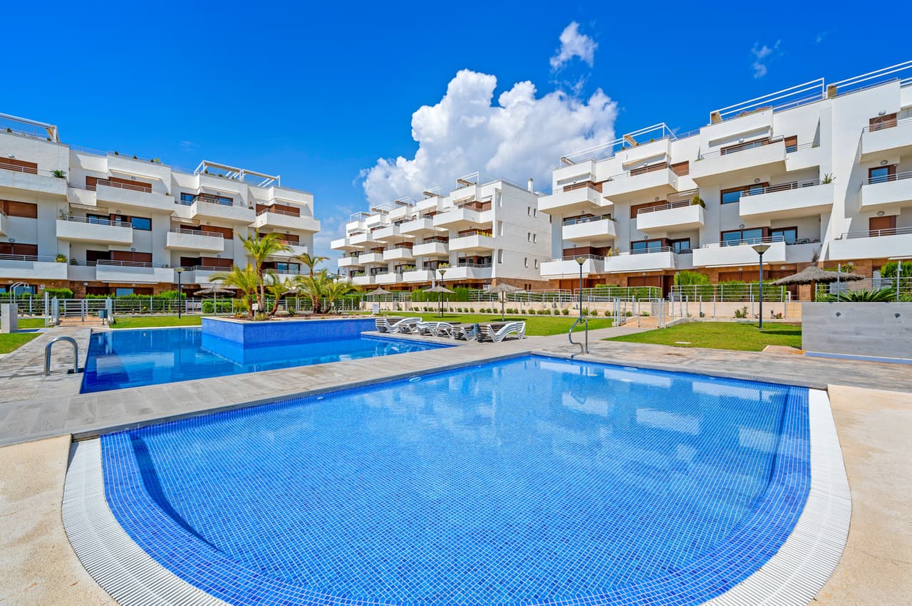 This beautiful well maintained modern style apartment with 2 bedrooms and with sea views from the terrace is situated in Lomas de Cabo Roig, Alicante. This south facing second floor apartment will be sold fully furnished and consists of a bright living/dining room, a fully equipped American style kitchen, utility room, two bedrooms with fitted wardrobes, two bathrooms (one is en-suite), air conditioning (hot/cold) throughout the property and a large terrace (16sqm) with sea views and overlooking the communal garden with swimming pool. Private parking space in the underground garage is also included in the price! There is a lovely communal garden with several swimming pools, jacuzzi, children's playground + sports area on this gated community.