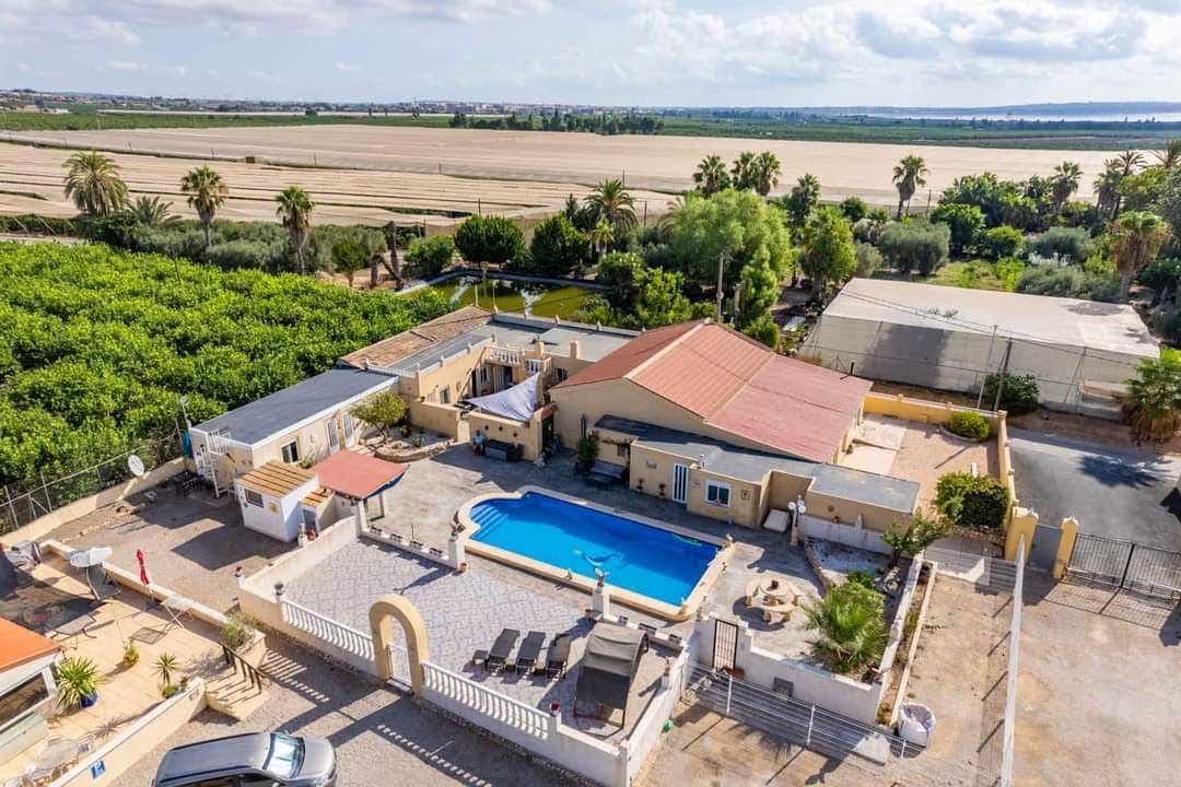CASA DE ENSUEÑO en la hermosa Los Montesinos, Alicante, España! ¡Esta Finca/Villa única es una oportunidad fantástica para invertir en la casa de sus sueños con innumerables posibilidades! La casa tiene 382m2. y sus instalaciones parecen bien mantenidas y modernas con el encanto tradicional español. En Los Montesinos podrás disfrutar plenamente del ambiente y la tranquilidad españoles sin dejar de estar cerca de todas las instalaciones y servicios. Esta finca/villa es perfecta para aquellos que quieran gestionar, por ejemplo, un Bed & Breakfast o un camping ya establecido. Hay 2 piscinas, una de las cuales actualmente es utilizada por el actual propietario y la otra como zona de piscina para un posible b&b o camping, con zonas realmente bonitas para muchas reuniones sociales y barbacoas. ¡Aquí obtienes una muy buena inversión con la opción de alquilar campings y bed and breakfast! En la villa privada encontrará 3 dormitorios y 4 baños con acceso a la piscina privada de 6x11 metros. En la parte de alquiler encontrará una piscina cerrada y un total de 40 camas, 12 aseos y 7 baños. La parcela de 7700m2 contiene un exuberante jardín con hermosos árboles, plantas y asientos al aire libre, todo lo cual ofrece un hermoso y tranquilo oasis con vistas a los alrededores. 6 caravanas (de las cuales 2 son de alquiler de larga duración) de 30m2 cada una Además, esta fantástica vivienda y parcela ofrece: Un bar de 40m2 para reunir a familiares e invitados en reuniones festivas en los hermosos días y tardes soleados. Grandes ventajas de esta propiedad; Electricidad gratuita, ya que hay un sistema solar en el tejado que puede generar 5,5 kw por hora. De esta forma, de forma privada, tendrás un consumo gratuito de electricidad y, al mismo tiempo, podrás facturar electrónicamente a cada usuario de cada caravana en concepto de alquiler. Alquiler de caravanas; Actualmente establecido con 2 contratos de arrendamiento a largo plazo por 700 euros + electricidad al mes. 4 caravanas con 97 euros + electricidad al día. Amplio aparcamiento para varios vehículos. Parcialmente amueblado Equipo adicional: Aire acondicionado, calefacción central y muchas otras instalaciones. Orientación: Orientación sur Los Montesinos está cerca de fantásticas playas, campos de golf, restaurantes, tiendas. Distancias : 2 km hacia Los Montesinos 14 km hasta Torrevieja 4 km hasta la autopista 54 km al aeropuerto de Alicante Precio de licitación 900.000 € sin IVA Bienvenido a finalmente contactarnos para obtener más información y una muestra privada.