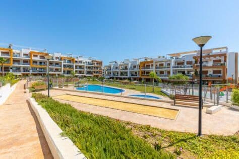 Modern Ground-Floor Apartment with Private Garden & Jacuzzi in residential Gala, Los Dolses, Villamartin, Alicante Residencial Gala is a modern, gated development (2019) near Villamartín Golf and La Zenia’s beach and shopping. It boasts a communal pool, children’s pool, jacuzzi, gardens, lift access, parking, and comforts like air conditioning and built-in wardrobes—making it ideal for year-round living or holidays. This stylish 68m² apartment offers comfort, convenience, and a fantastic location on the Costa Blanca. Featuring 2 bedrooms and 2 bathrooms, a bright living room with an open kitchen, and a separate laundry room, it’s designed for both everyday living and holiday relaxation.  Enjoy the outdoors with a 20m² terrace and a 52m² private garden complete with a jacuzzi — perfect for use all year round. The residence also boasts a spacious communal swimming pool and a smaller pool for children, making it ideal for families.  Perfectly situated just 2 km from the beach, the apartment is also close to vibrant leisure areas and only 1 km from the renowned Villamartín Golf Course, the oldest and one of the best in Alicante.  Features & Details • Bedrooms: 2 • Bathrooms: 2 • Usable space: 68m² • Terraces: 20m² (2 private terraces + porch) • Private garden: 52m² with jacuzzi • Community pool + children’s pool • Orientation: East • Condition: Excellent • Floor: Ground floor • Air conditioning • Furnished • Playground & communal garden Location: • Beach: 2 km • Entertainment: 5 min walk • Golf: 1 km • Airport: 45 min drive  Contact us today