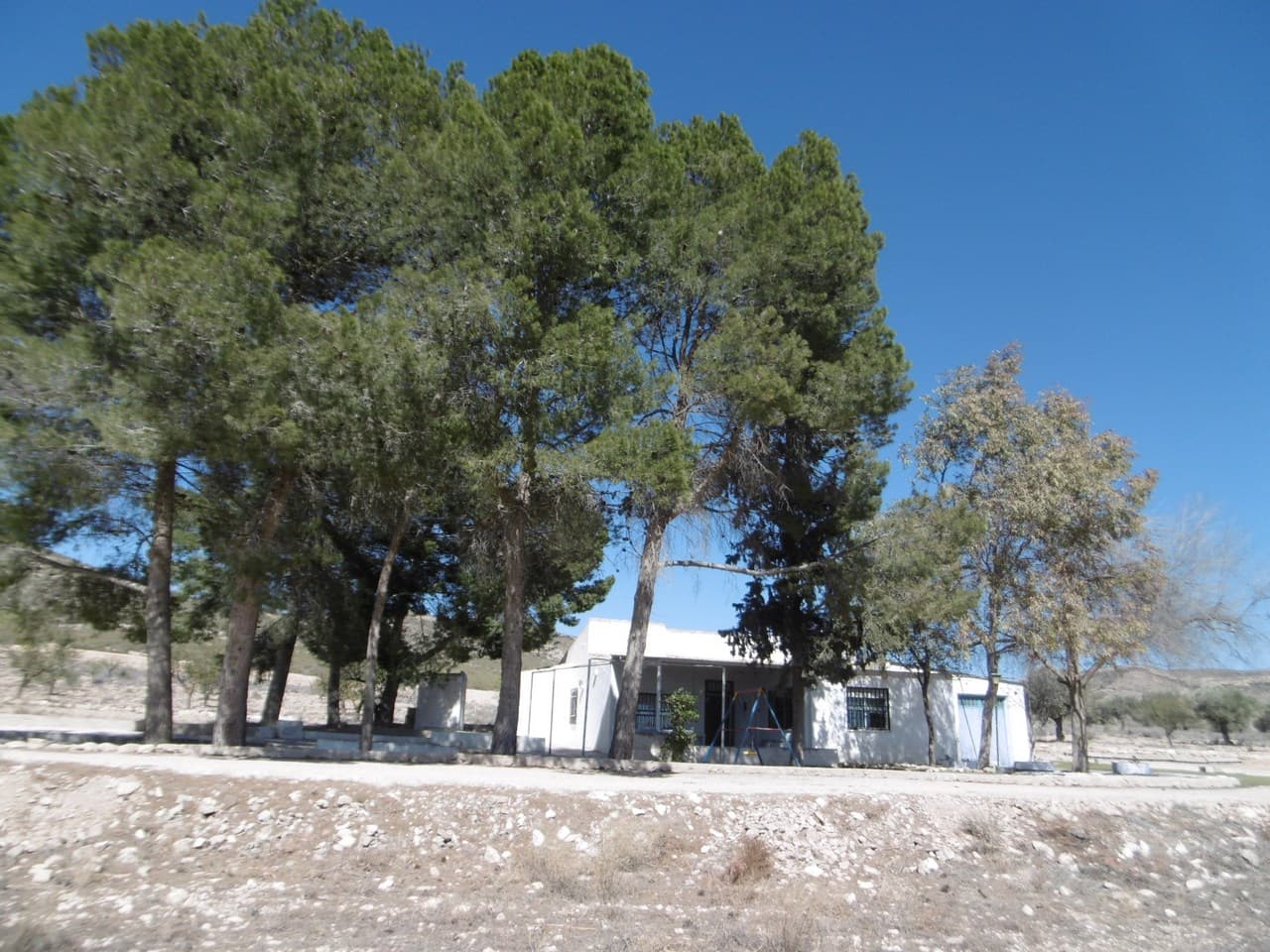 Bienvenidos a esta encantadora casa de campo, enclavada en una ubicación privilegiada rodeada de belleza natural. Con una superficie de 178 m², con 138 m² dedicados a la superficie habitable y un garaje adicional de 40 m², esta propiedad se encuentra en una amplia parcela de más de 14.000 m². La casa cuenta con 4 dormitorios, 1 baño y una cocina moderna y espaciosa, lo que proporciona un amplio espacio para una vida cómoda. Salga para descubrir una zona de barbacoa al aire libre, perfecta para entretenerse y disfrutar del impresionante entorno. Con orientación sur, la propiedad se beneficia de abundante luz natural y cuenta con excelentes vistas del paisaje circundante. Los frondosos pinos, higueras y almendros crean una atmósfera tranquila, ideal para relajarse y rejuvenecer. Ubicada cerca de las montañas en un área natural, esta propiedad ofrece el refugio perfecto para los entusiastas de la naturaleza. Su amplio espacio y su entorno sereno lo convierten en una opción ideal para quienes buscan disfrutar de la vida en el campo, con la ventaja adicional de ser perfecto para los caballos. Tenemos una gran cartera de propiedades en las zonas de la Costa Blanca y Costa Cálida, especializándonos en propiedades de campo, villas, fincas, solares edificables y opciones de diseño y construcción en las regiones de Alicante y Murcia con especial énfasis en Elda, Monovar, Pinoso, Sax. , Villena, Aspe, Fortuna, Albacete y muchas más zonas de los alrededores. Nos establecimos desde 2004 y contamos con décadas de experiencia en el equipo que aportamos para ayudarlo a encontrar y asegurar la nueva casa de sus sueños. Te ayudamos en cada paso del camino para asegurarnos de que tu compra en España sea segura y sin complicaciones. No estamos aquí para venderle una propiedad, estamos aquí para ayudarlo a realizar su sueño y encontrar lo que es adecuado para usted. Con nosotros estás en las manos más seguras. Contáctanos ahora para conversar sin compromiso sobre cómo tú también puedes hacer realidad tus sueños.