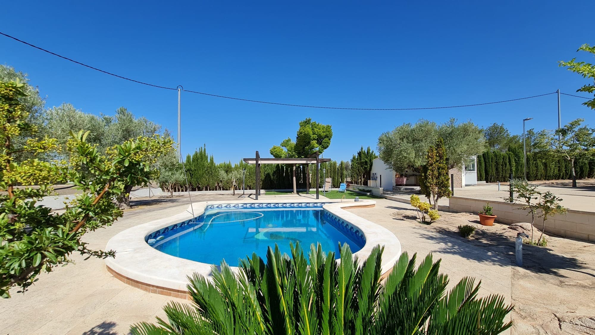 ¡Bienvenido a la casa de tus sueños! Esta espaciosa propiedad ofrece todo lo que necesita para una vida cómoda y entretenida. Con 175 metros cuadrados de construcción, encontrarás una acogedora sala de estar con una acogedora chimenea, una cocina bien equipada, una galería y dos baños. La propiedad cuenta con cinco dormitorios, incluido un ático versátil con terraza que fácilmente podría transformarse en otro dormitorio principal y baño. En el exterior, descubrirá una carpa, perfecta para relajarse o celebrar reuniones al aire libre, junto con una zona de barbacoa y un cómodo espacio de almacenamiento. Date un chapuzón en la espectacular piscina, que cuenta con un jacuzzi y relucientes azulejos de gresite, y disfruta de la comodidad de un sistema de purificación. Manténgase conectado con Internet de fibra de alta velocidad y estacione sus vehículos con facilidad en el amplio estacionamiento para hasta cuatro autos. La propiedad se beneficia de calefacción de agua, electricidad y gasóleo, con el confort añadido de aire acondicionado y chimenea que distribuye el aire caliente por toda la casa. Las ventanas de doble acristalamiento y los mosquiteros garantizan comodidad durante todo el año, mientras que los 5.400 metros cuadrados de terreno vallado, con frondosos árboles y una puerta automática, ofrecen privacidad y tranquilidad. ¡No pierdas la oportunidad de hacer de este tu hogar para siempre! Tenemos una gran cartera de propiedades en las zonas de la Costa Blanca y Costa Cálida, especializándonos en propiedades de campo, villas, fincas, solares edificables y opciones de diseño y construcción en las regiones de Alicante y Murcia con especial énfasis en Elda, Monovar, Pinoso, Sax. , Villena, Aspe, Fortuna, Albacete y muchas más zonas de los alrededores. Nos establecimos desde 2004 y contamos con décadas de experiencia en el equipo que aportamos para ayudarlo a encontrar y asegurar la nueva casa de sus sueños. Te ayudamos en cada paso del camino para asegurarnos de que tu compra en España sea segura y sin complicaciones. No estamos aquí para venderle una propiedad, estamos aquí para ayudarlo a realizar su sueño y encontrar lo que es adecuado para usted. Con nosotros estás en las manos más seguras. Contáctenos ahora para conversar sin compromiso sobre cómo usted también puede hacer realidad sus sueños.