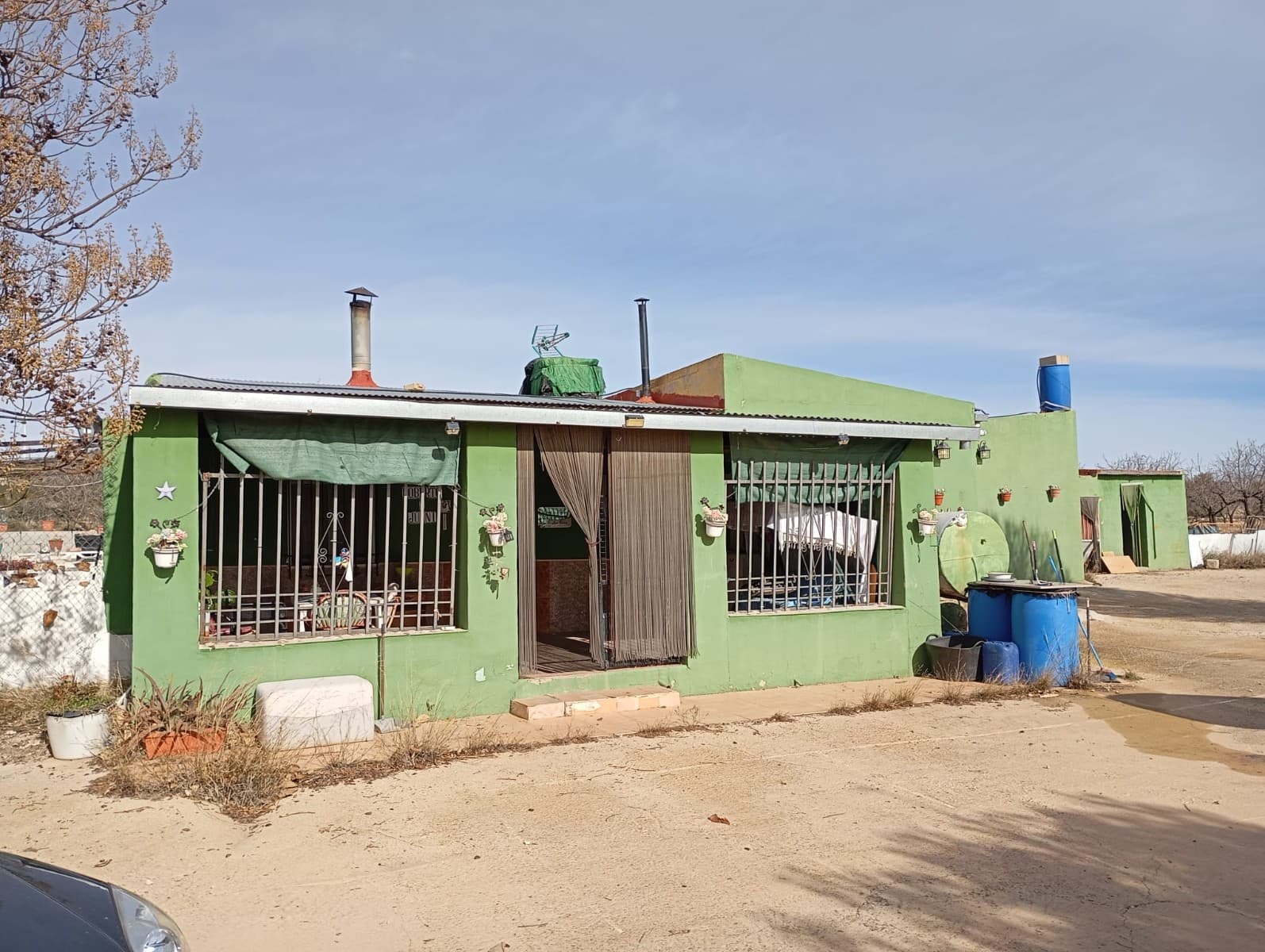 ¡Encantadora propiedad rural con potencial infinito! - A 12 minutos de Yecla Esta exclusiva y espaciosa casa de campo ofrece una oportunidad increíble para quienes buscan crear el refugio de sus sueños. Ubicada en una parcela generosa, la propiedad cuenta con tres dormitorios, dos baños, un acogedor salón con chimenea, una cocina independiente y un gran porche cubierto, perfecto para disfrutar de la tranquilidad del entorno. Los espacios exteriores incluyen una zona de barbacoa, un pequeño trastero y una cochera para tres coches. Además, la propiedad cuenta con un gran depósito de agua que podría convertirse en piscina, lo que añade aún más valor a esta fantástica ganga. Aunque no hay agua corriente ni electricidad en la zona, los propietarios actuales utilizan un generador y un sistema de baterías para las estancias de fin de semana. Para una solución más permanente, recomendamos instalar un sistema solar de 5 kilovatios, cuyo coste se estima en unos 7000 €. La propiedad también se beneficia de varios tanques de recogida de agua de lluvia, con la opción de disponer de agua cuando sea necesario. Necesita algunas reformas y cuidados, pero con la visión adecuada, esta casa podría convertirse en algo verdaderamente especial. A este precio, no estará en el mercado por mucho tiempo. ¡Contáctenos hoy para programar una visita! Sobre el área: Ubicada a solo 15 km de Yecla, esta propiedad es ideal para quienes buscan un estilo de vida rural tranquilo y estar cerca de los servicios esenciales. Yecla es conocida por su producción de vino, su encantador centro histórico y su vibrante cultura local. La ciudad ofrece supermercados, restaurantes, instalaciones médicas y escuelas, lo que la convierte en una ubicación conveniente tanto para vivir de forma permanente como para escapadas de fin de semana. Con amplios espacios abiertos y un entorno natural impresionante, esta casa es perfecta para cualquiera que quiera disfrutar de la belleza del campo español. Contamos con una amplia cartera de propiedades en las zonas de la Costa Blanca y Costa Cálida, especializándonos en propiedades en el campo, villas, fincas, parcelas edificables y opciones de diseño y construcción en las regiones de Alicante y Murcia, con especial énfasis en Elda, Monovar, Pinoso, Sax, Villena, Aspe, Fortuna, Albacete y muchas más áreas circundantes. Estamos establecidos desde 2004 y contamos con décadas de experiencia entre el equipo que ponemos a su disposición para ayudarle a encontrar y asegurar la nueva casa de sus sueños. Le ayudamos en cada paso del proceso para asegurarnos de que su compra en España sea segura y sin complicaciones. No estamos aquí para venderle una propiedad, estamos aquí para ayudarle a hacer realidad su sueño y encontrar lo que es adecuado para usted. Con nosotros está en las mejores manos. Póngase en contacto con nosotros ahora para tener una charla sin compromiso sobre cómo usted también puede hacer realidad sus sueños.