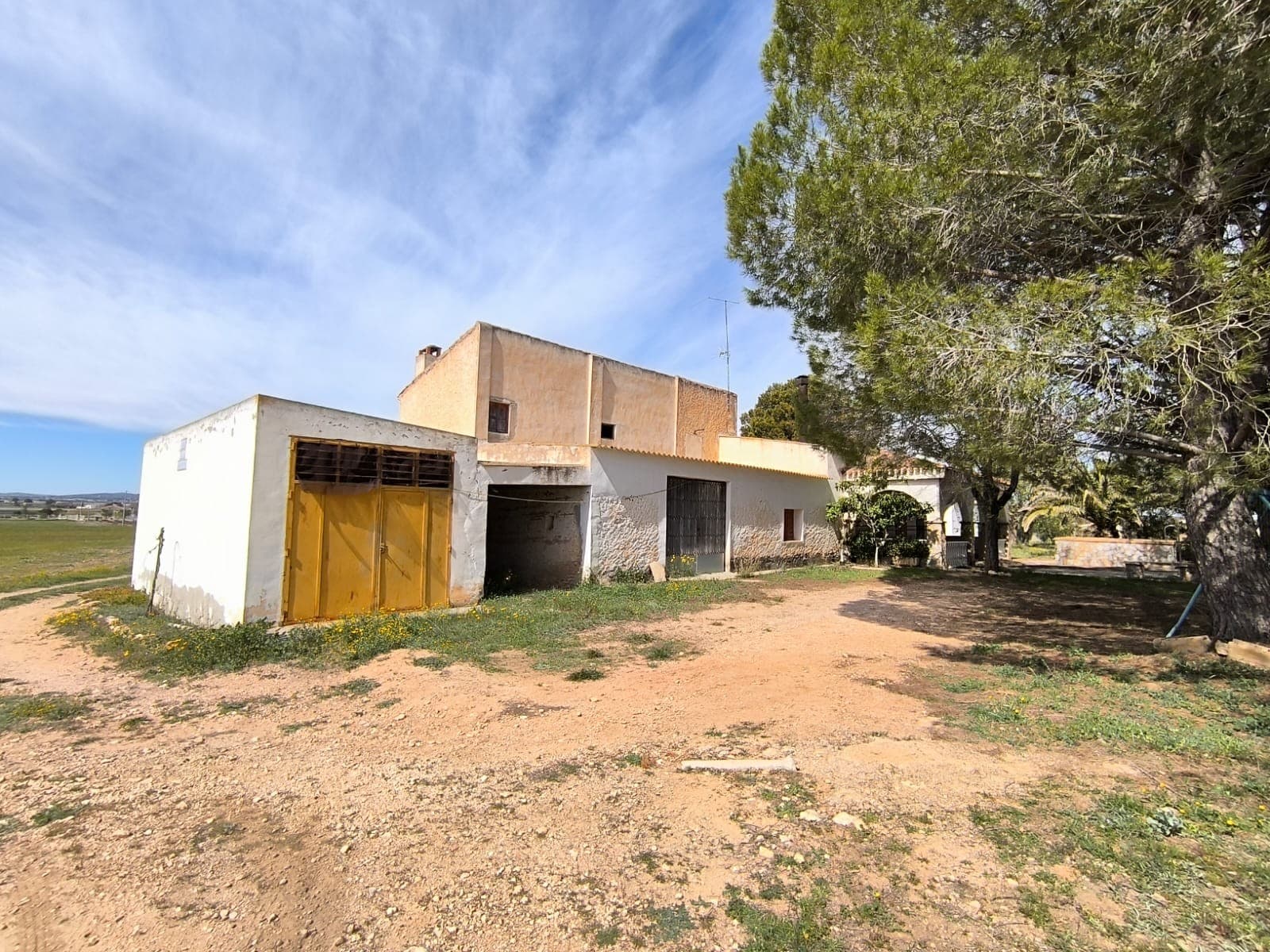 Highly adaptable rural property, complete with its own independent water supply. Featuring existing agricultural facilities and excellent development potential.The farmhouse – residential area The detached farmhouse is divided into two sections: agricultural and residential. The residential part is structurally solid and ready to move into, offering:5 bedrooms 2 living rooms, each with a fireplace open-plan kitchen 1 bathroom two independent entrances, making it easy to split into two separate living spaces swimming poolAlthough some modernization could enhance the interior, the house provides a strong structure and versatile layout. Outside, a south-facing terrace overlooks open, private surroundings, with a small pool positioned at the front of the home.Agricultural area and additional buildings Connected to the main house is a practical agricultural section, which includes:3 garages 2 extra rooms with fireplaces spacious upper-level storage area2 tractors and 1 trailera storage space with barbecue area a bathroom with independent external accessKey feature – private water supply and utilitiesPrivate registered well with extraction rights of up to 24,000 m³ per year or 90 m³ per day, access to mains irrigation water with established usage rights, large 330 m³ water deposit for water storage, or potential conversion into an impressive private pool. Mains electric.Land and plot Set on a spacious 113,600 m² plot, the land, flat and fertile, is mostly and ready for cultivation. It also features an olive grove with around 60 mature trees.Location and surroundings Located in a tranquil and traditional Spanish countryside setting, the property offers peace and quiet, fresh air, and no traffic disturbance. A nearby town with all essential amenities is just a 12-minute drive away.Lifestyle and possibilities This property is ideal for:farming or horticultural projects – vineyards, orchards, vegetable growing, or keeping animals such as dogs, horses, or goats agrotourism or rural guest accommodation (tourist license not yet obtained) a self-sufficient or environmentally conscious lifestyle multi-family living or rental opportunitiesWith its space, privacy, and existing infrastructure, this property presents a rare opportunity to create a sustainable rural project or simply enjoy a peaceful life in nature without losing easy access to services.For more information, you can view the narrated walkthrough video available on our website.About the area: Yecla is a charming and historic town of app. 35000 inhabitants, located in the region of Murcia. It is renowned for its award-winning wines, historical landmarks, and vibrant local culture. The surrounding natural landscapes of scenic mountains, vineyards and almond groves provide opportunities for outdoor activities, while the town itself offers all necessary services, including hospital, schools, shops, restaurants, and other services. With a friendly local community, lively markets, excellent gastronomy, and easy access to nature, Yecla is an ideal location for those seeking authentic Spanish lifestyle - just about an hour from the coast and Alicante airport.About us: We have a large portfolio of properties in the Costa Blanca and Costa Calida areas, specialising in country properties, villas, fincas, building plots and design and build options in the Alicante and Murcia regions with a particular emphasis on Yecla, Novelda, Elda, Monovar, Pinoso, Sax, Villena, Aspe, Fortuna, Jumilla, Abanilla, and many more surrounding areas. We have been established since 2004 and have decades of experience between the team which we bring to bear to help you find and secure your new dream home. We help you every step of the way to make sure your purchase in Spain is safe and hassle free. We are not here to sell you a property, we are here to help you realise your dream and find what is right for you. With us you are in the safest hands. Contact us now to have a no obligation chat about how you too can realise your dreams.