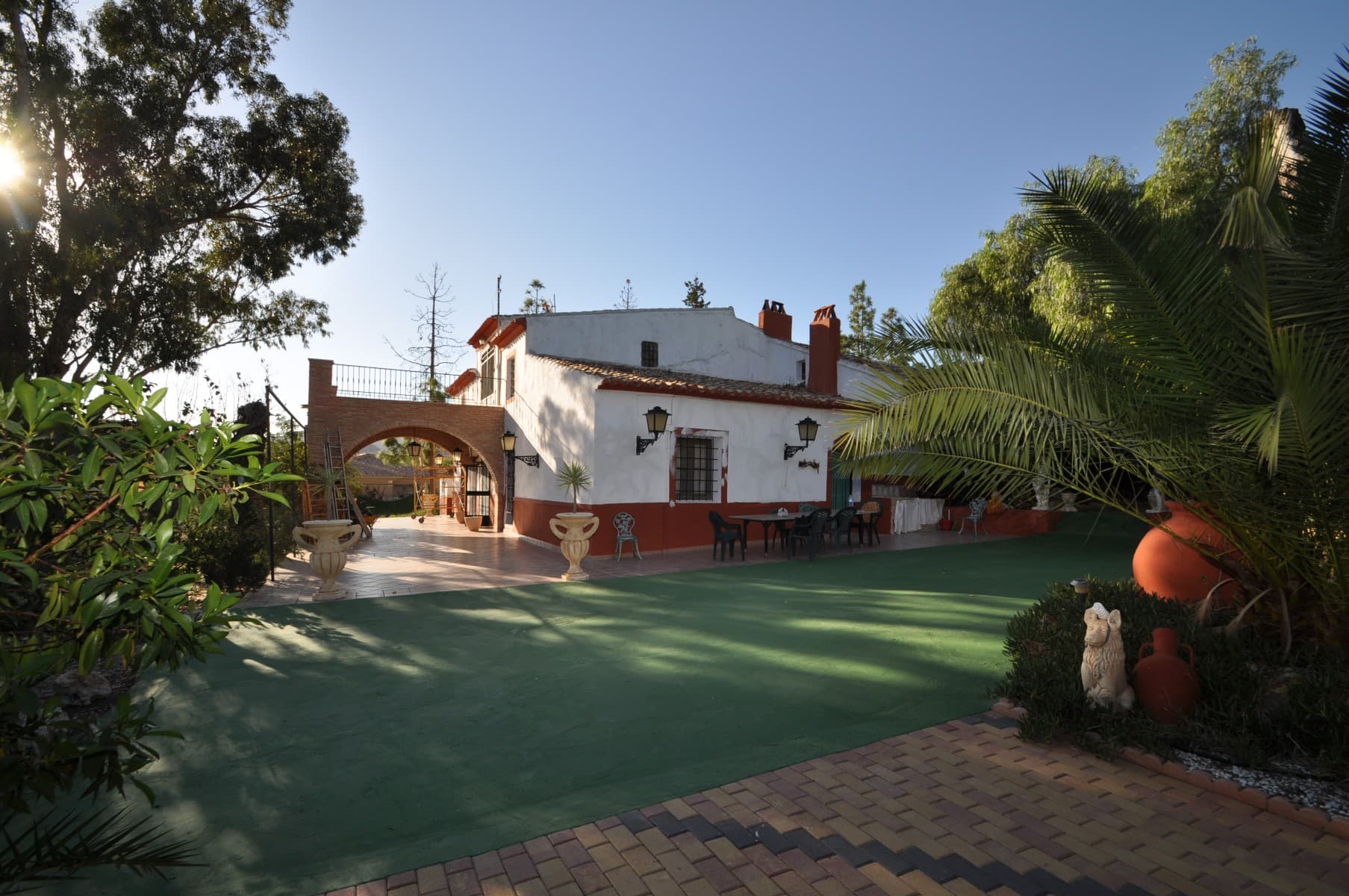 This beautiful ancient house, with its landscaped gardens, swimming pool and tennis court, in a quiet area, is only five minutes drive from the seaside resort Los Banos, famous for its hot spring water throughout the year. but also close to Fortuna, lively town where you can find all amenities. This villa located in a very quiet area and is surrounded by mountain views.As you go into the house you will be embraced by its rustic massive kitchen, leading to two large lounge/dining room with an open oven / fire place. It also comprises two large bedrooms and one family bathroom and upstairs another two large bedrooms with one bedroom opening onto a balcony. This villa also benefits from an attached annex that could be converted into two to three bedrooms and one bathroom with its own entrance. it continues to two large warehouses, stables, garage and a large storage, again, this could be reformed as accommodation too. As you stroll along the lovely gardens with its fountain, and various trees, leading to a large summer kitchen area with its swimming pool and a chalet with showers and toilet room. It also carries on with orchards and its own tennis court. This property, all fenced up and with an alarmed system, has potential as a guest house or if you wish to trace the old age or simply wants to entertain friends or family there is plenty to do. here is another 2000 m2 plot to buy which is a bonus for the property.Most importantly the land is urban and can be used to build more houses if required.  If you have any queries or wish to view this property, please do not hesitate to contact us.We are specialists in the Costa Blanca and Costa Calida specialising in the Alicante and Murcia Inland regions with a particular emphasis on Elda, Pinoso, Aspe, Elche and surrounding areas. We are an established, well known and trusted company that has built a solid reputation amongst buyers and sellers since we began trading in 2004. We offer a complete service with no hidden charges or surprises, starting with sourcing the property, right through to completion, and an unrivalled after sales service which includes property management, building services, and general help and advice to make your new house a home. With a portfolio of well over 1400 properties for sale, we are confident that we can help, so just let us know your preferred property, budget and location, and we will do the rest.