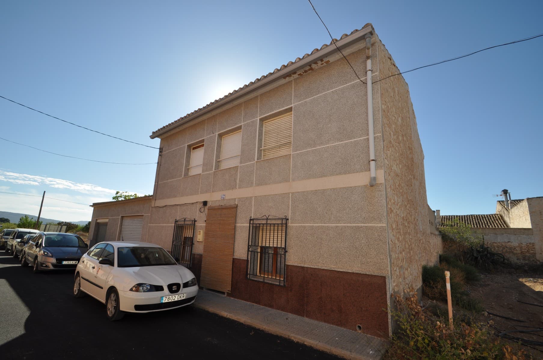 Bienvenido a esta impresionante casa de campo ubicada en una pequeña y pintoresca aldea, a tiro de piedra de la vibrante ciudad de Pinoso. Esta hermosa propiedad ofrece la combinación perfecta de comodidades modernas y encanto tradicional, lo que la convierte en el hogar ideal para aquellos que buscan un estilo de vida tranquilo y cómodo. Con 5 dormitorios de generosas dimensiones y 2 baños, esta espaciosa propiedad tiene una superficie construida total de aproximadamente 211 metros cuadrados y se asienta sobre una parcela de 290 metros cuadrados. La casa está completamente conectada a la red eléctrica y al agua, y también tendrá acceso a Internet de alta velocidad y conexiones telefónicas, lo que le permitirá mantenerse conectado con el mundo que lo rodea. Una de las características sobresalientes de esta propiedad es su excelente acceso a través de una carretera asfaltada, lo que facilita la entrada y salida de la ciudad. Además, la propiedad se encuentra a pocos pasos de bares y restaurantes, lo que la convierte en el lugar perfecto para aquellos que disfrutan salir a cenar y socializar. Otro gran beneficio de vivir en esta aldea son las entregas regulares de productos frescos a la puerta de tu casa. Puede disfrutar de frutas, verduras, carne y pan cultivados localmente sin tener que salir de casa. La propiedad también cuenta con tres amplios garajes, que son perfectos para almacenamiento o conversión en espacio habitable adicional. Esto significa que tendrá mucho espacio para todas sus pertenencias e incluso puede agregar más espacio habitable a la casa si es necesario. En general, esta casa de campo está llena de carácter y ofrece la combinación perfecta de una vida tranquila con todas las comodidades que necesita. ¡No pierda esta fantástica oportunidad de hacer de esta hermosa propiedad la casa de sus sueños! Disponemos de una amplia cartera de propiedades en las zonas de la Costa Blanca y la Costa Cálida, especializada en fincas, villas, fincas, solares edificables y opciones de diseño y construcción en las regiones de Alicante y Murcia, con especial énfasis en Elda, Monovar, Pinoso, Sax , Villena, Aspe, Fortuna, Albacete y muchos más alrededores. Estamos establecidos desde 2004 y tenemos décadas de experiencia entre el equipo que aportamos para ayudarlo a encontrar y asegurar la nueva casa de sus sueños. Te ayudamos en cada paso del camino para asegurarnos de que tu compra en España sea segura y sin complicaciones. No estamos aquí para venderle una propiedad, estamos aquí para ayudarlo a realizar su sueño y encontrar lo que es adecuado para usted. Con nosotros estás en las manos más seguras. Contáctenos ahora para tener una charla sin compromiso sobre cómo usted también puede realizar sus sueños.