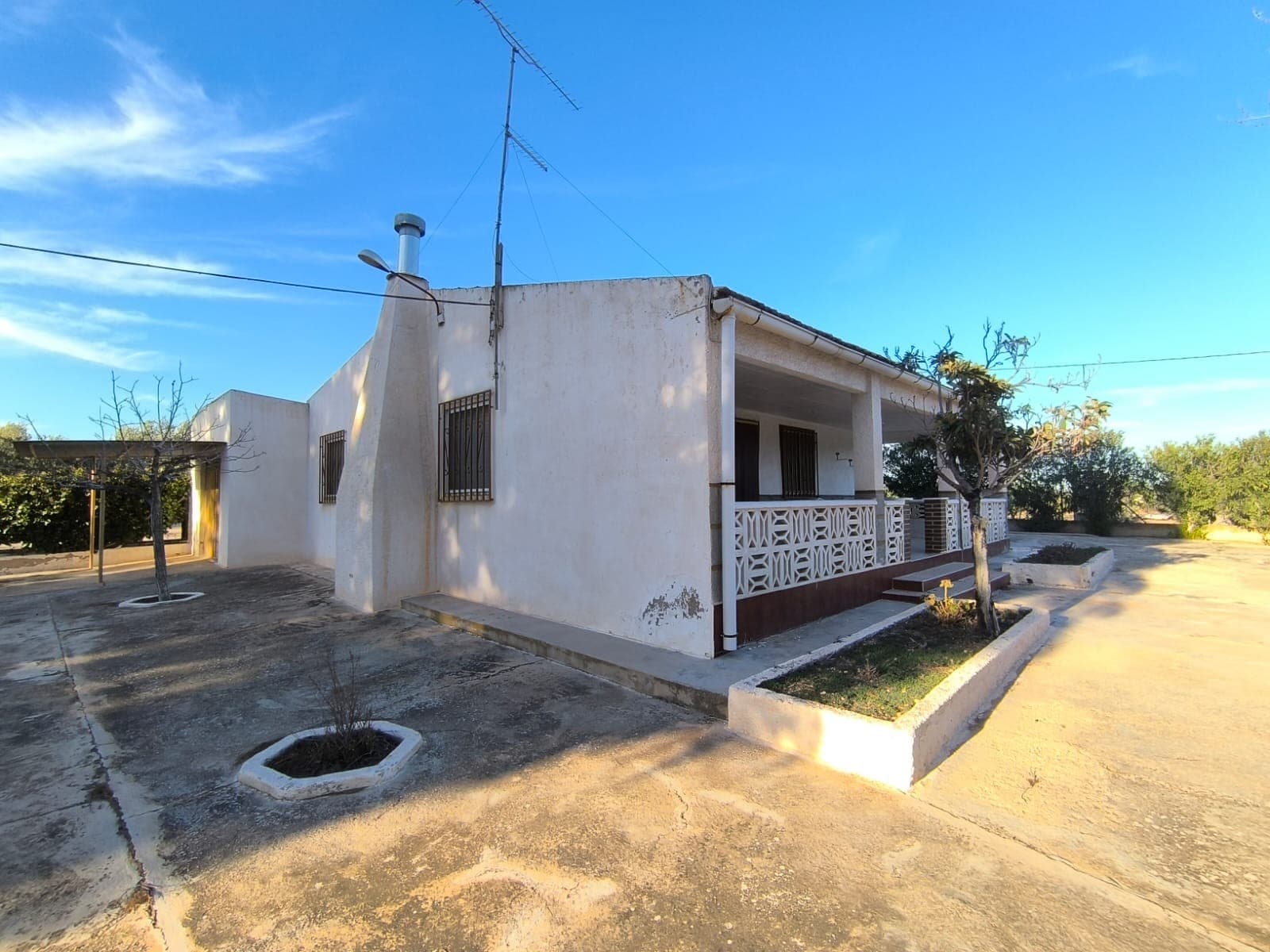 En venta: Descubra esta encantadora villa ubicada en una tranquila zona rural al sur de Yecla, con fácil acceso por carretera asfaltada. Disfrute de impresionantes vistas a la montaña desde la comodidad de su nuevo hogar. Esta propiedad se encuentra en buen estado y lista para entrar a vivir. Su interior antiguo ofrece la oportunidad de renovarla a su gusto. La casa cuenta con 255 m², que incluyen 3 amplios dormitorios, un baño, cocina y varios trasteros. Además, incluye un amplio garaje. La casa cuenta con 3 chimeneas. La villa se vende completamente amueblada y cuenta con luz pública y dos tipos de agua para riego. En el exterior encontrará un hermoso jardín vallado, a la sombra de pinos maduros, una gran piscina vallada con zona de barbacoa, un almacén con corral para perros, césped, cochera y un parque infantil. La propiedad también cuenta con un olivar de regadío de aproximadamente 2500 m², que ofrece la posibilidad de producir su propio aceite de oliva. Esta magnífica ubicación combina a la perfección tranquilidad y accesibilidad, convirtiéndola en un refugio ideal. Sobre la zona: Yecla es famosa por su producción vinícola, sus monumentos históricos y su vibrante cultura local. Los paisajes naturales que la rodean ofrecen la oportunidad de practicar actividades al aire libre, mientras que el pueblo ofrece todos los servicios necesarios, como escuelas, tiendas y restaurantes. Esta propiedad combina la tranquilidad de la vida rural con fácil acceso a servicios modernos. Sobre nosotros: Contamos con una amplia cartera de propiedades en la Costa Blanca y la Costa Cálida, especializándonos en fincas, villas, fincas, terrenos edificables y opciones de diseño y construcción en las regiones de Alicante y Murcia, con especial énfasis en Elda, Monóvar, Pinoso, Sax, Villena, Aspe, Fortuna, Albacete y muchas otras zonas de los alrededores. Llevamos establecidos desde 2004 y nuestro equipo cuenta con décadas de experiencia para ayudarle a encontrar y asegurar la casa de sus sueños. Le acompañamos en cada paso del proceso para garantizar que su compra en España sea segura y sin complicaciones. No estamos aquí para venderle una propiedad, sino para ayudarle a hacer realidad su sueño y encontrar la propiedad perfecta para usted. Con nosotros, está en las mejores manos. Contáctenos ahora para hablar sin compromiso sobre cómo usted también puede hacer realidad sus sueños.