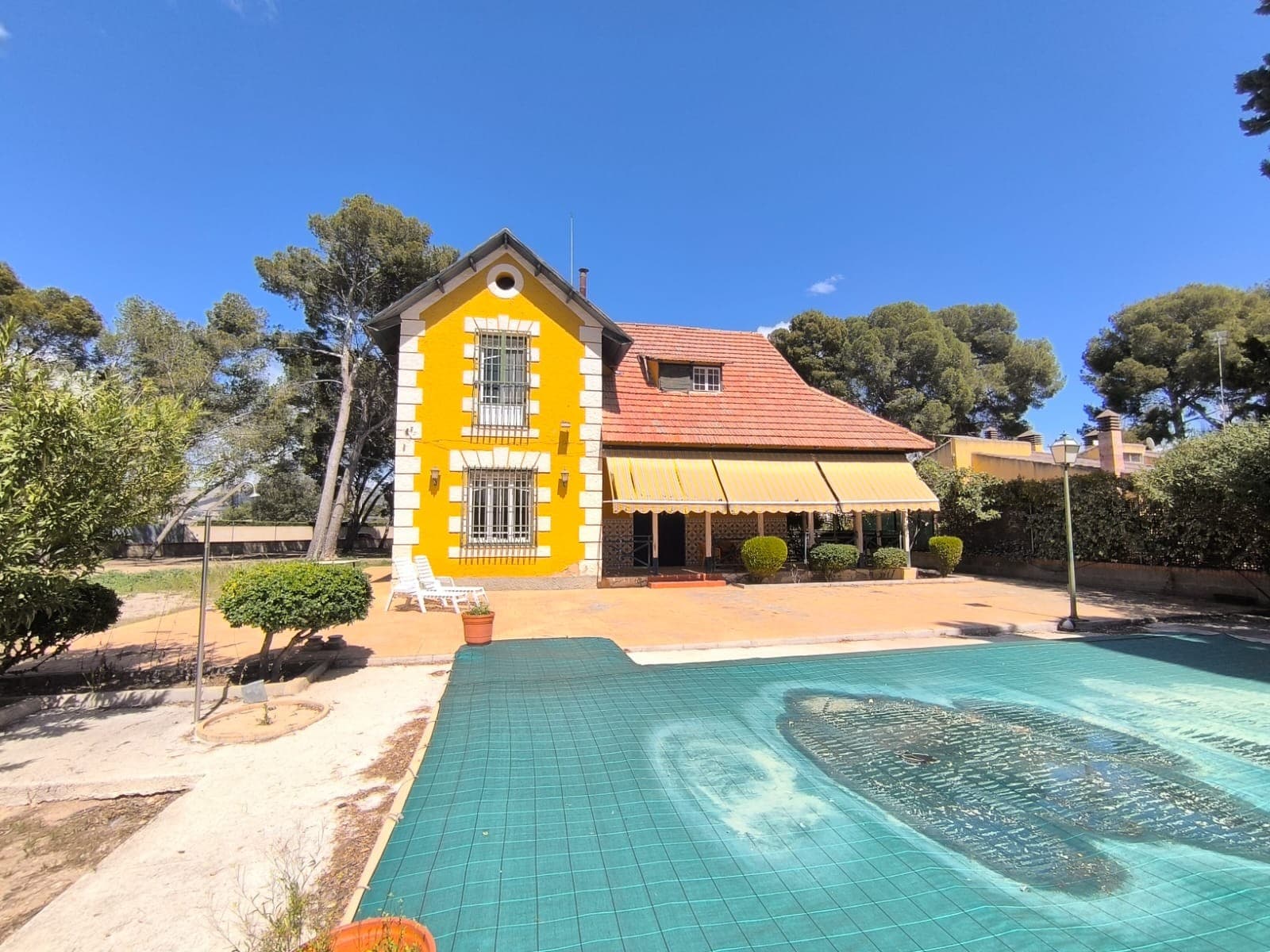 ¡Preciosa villa de 1910 en una ubicación exclusiva! Descubra una oportunidad única para adquirir una impresionante villa, llena de historia y encanto, a solo 10 minutos a pie de servicios esenciales como un hospital, un colegio, tiendas y el centro histórico de Yecla. Esta propiedad cuenta con dos casas independientes, cada una con su propio potencial y carácter. La primera casa es una villa de dos plantas, bien cuidada. Incluye siete dormitorios (4 grandes y 3 pequeños), dos baños (uno privado para el dormitorio principal), una cocina totalmente equipada y varios trasteros. La villa también cuenta con dos elegantes salones, uno de los cuales tiene acceso a una terraza cubierta. El interior está decorado con una elegante escalera antigua y muebles de diseño, que reflejan el estilo y la esencia únicos de la villa. La segunda casa ofrece una oportunidad de restauración. Si bien la construcción es sólida, el interior espera tu visión creativa para transformarlo en un espacio personalizado. Incluye garaje y varios trasteros. El jardín de casi 5000 m² goza de una hermosa sombra gracias a los pinos maduros y está completamente vallado para mayor privacidad. Un portón eléctrico facilita el acceso, y aunque la mayoría de las zonas del jardín son tranquilas, algunas ofrecen pintorescas vistas del centro histórico de Yecla. La propiedad también cuenta con dos piscinas: una moderna piscina rectangular situada justo en frente de la casa, y una piscina circular que necesita restauración, lo que proporciona un mayor potencial para el ocio y la relajación. Esta villa cuenta con servicios básicos como electricidad, agua potable y alcantarillado, lo que la convierte en una combinación perfecta de encanto histórico y comodidades modernas. ¡No pierda la oportunidad de adquirir esta excepcional propiedad! Sobre la zona: Yecla es famosa por su producción vinícola, sus monumentos históricos y su vibrante cultura local. Los paisajes naturales que la rodean ofrecen la oportunidad de practicar actividades al aire libre, mientras que el pueblo ofrece todos los servicios necesarios, como escuelas, tiendas y restaurantes. Esta propiedad combina la tranquilidad de la vida rural con fácil acceso a servicios modernos. Sobre nosotros: Contamos con una amplia cartera de propiedades en la Costa Blanca y la Costa Cálida, especializándonos en fincas, villas, fincas, terrenos edificables y opciones de diseño y construcción en las regiones de Alicante y Murcia, con especial énfasis en Elda, Monóvar, Pinoso, Sax, Villena, Aspe, Fortuna, Albacete y muchas otras zonas de los alrededores. Llevamos establecidos desde 2004 y nuestro equipo cuenta con décadas de experiencia para ayudarle a encontrar y asegurar la casa de sus sueños. Le acompañamos en cada paso del proceso para garantizar que su compra en España sea segura y sin complicaciones. No estamos aquí para venderle una propiedad, sino para ayudarle a hacer realidad su sueño y encontrar la propiedad perfecta para usted. Con nosotros, está en las mejores manos. Contáctenos ahora para hablar sin compromiso sobre cómo usted también puede hacer realidad sus sueños.
