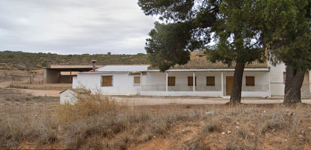¡Le presentamos esta casa de campo adosada a un precio muy atractivo! La propiedad cuenta con una espaciosa casa de campo de fácil acceso de 140 m² en una sola planta, porche cubierto y dos amplios garajes (90 m² + 140 m²), que pueden convertirse en establos o talleres. Ubicada a solo 7 km de Yecla, la casa cuenta con 2 dormitorios (con posibilidad de añadir 2 más), un baño, un salón y un amplio comedor con cocina integrada, equipada con chimenea para mayor calidez y ambiente. La propiedad necesita algunas reformas, está adosada a la casa vecina por un lado y se encuentra muy cerca de una carretera principal, lo que genera algo de ruido. La casa incluye un generoso terreno de 237.400 m², que incluye 120.000 m² de naturaleza salvaje, 120.000 m² de campo y 5.000 m² de olivar. El terreno no es compacto. La casa vecina, que comparte pared, patio y depósito con esta propiedad, también está a la venta: 41045a-PB Por un precio combinado de 200.000 €, podría comprar ambas propiedades a la vez para ganar casi 400.000 m² de terreno. El suministro de agua está garantizado mediante un pozo privado y un depósito de agua. La propiedad no está conectada a la red eléctrica. Si bien necesita un sistema solar y cableado nuevo, ofrece la oportunidad de vivir sin conexión a la red. Enclavada en un pintoresco entorno natural, la casa ofrece vistas panorámicas. Gracias a su ubicación y a su amplio terreno, esta propiedad es ideal para los amantes de la equitación y para plantar olivos, almendros, pistachos o viñedos. No pierda la oportunidad de adquirir este versátil y sereno refugio rural. Sobre la zona: Yecla es famosa por su producción vinícola, sus monumentos históricos y su vibrante cultura local. Los paisajes naturales que la rodean ofrecen la oportunidad de practicar actividades al aire libre, mientras que el pueblo ofrece todos los servicios necesarios, como escuelas, tiendas y restaurantes. Esta propiedad combina la tranquilidad de la vida rural con fácil acceso a servicios modernos. Sobre nosotros: Contamos con una amplia cartera de propiedades en la Costa Blanca y la Costa Cálida, especializándonos en fincas, villas, fincas, terrenos edificables y opciones de diseño y construcción en las regiones de Alicante y Murcia, con especial énfasis en Elda, Monóvar, Pinoso, Sax, Villena, Aspe, Fortuna, Albacete y muchas otras zonas de los alrededores. Llevamos establecidos desde 2004 y nuestro equipo cuenta con décadas de experiencia para ayudarle a encontrar y asegurar la casa de sus sueños. Le acompañamos en cada paso del proceso para garantizar que su compra en España sea segura y sin complicaciones. No estamos aquí para venderle una propiedad, sino para ayudarle a hacer realidad su sueño y encontrar la propiedad perfecta para usted. Con nosotros, está en las mejores manos. Contáctenos ahora para hablar sin compromiso sobre cómo usted también puede hacer realidad sus sueños.