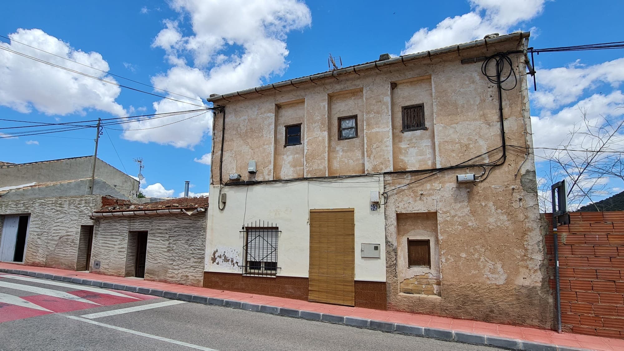 Descubra esta preciosa casa adosada independiente ubicada en el tranquilo y pintoresco pueblo de Algueña, Alicante. Con una combinación perfecta de comodidad, privacidad y conveniencia, esta propiedad es ideal para quienes buscan un estilo de vida relajado a poca distancia de los servicios diarios. La casa cuenta con un amplio patio de 233 m², perfecto para comer al aire libre, relajarse al sol o incluso cultivar un pequeño jardín. El garaje privado ofrece aparcamiento seguro y espacio de almacenamiento adicional. En el interior, encontrará una espaciosa cocina con un práctico trastero, un acogedor salón con chimenea tradicional y cuatro dormitorios bien proporcionados. Uno de los dormitorios se encuentra en la planta baja, lo que la hace ideal para invitados o para quienes prefieren vivir en un solo nivel. Ubicada frente a un encantador parque infantil, la propiedad es perfecta para familias o quienes disfrutan de espacios verdes abiertos cerca. La casa se encuentra en un entorno tranquilo, pero a un corto paseo de tiendas, cafeterías, un mercado semanal, una farmacia y otros servicios básicos. ¿Qué hay cerca? Algueña es un pueblo tradicional español con una comunidad amigable y un ritmo de vida más tranquilo. Disfrute de bares de tapas, panaderías y plazas con encanto. Los amantes de las actividades al aire libre apreciarán el paisaje circundante, ideal para caminar, hacer senderismo y montar en bicicleta. A solo 10 minutos en coche se encuentra el pueblo de Pinoso, conocido por su excelente selección de restaurantes, supermercados, escuelas y servicios de salud. Pinoso también acoge eventos culturales y festivales locales con regularidad, y cuenta con un animado mercado los sábados. Enlaces de transporte A pesar de su tranquila ubicación, Algueña está bien comunicada. La ciudad de Alicante y su aeropuerto internacional están a unos 45-50 minutos en coche, lo que ofrece fácil acceso tanto para viajes dentro de España como al extranjero. Las localidades costeras de la Costa Blanca también están cerca, lo que facilita disfrutar de días de playa o excursiones costeras. Disponemos de una amplia cartera de propiedades en la Costa Blanca y la Costa Cálida, especializándonos en fincas rústicas, villas, fincas, terrenos edificables y opciones de diseño y construcción en las regiones de Alicante y Murcia, con especial énfasis en Elda, Monóvar, Pinoso, Sax, Villena, Aspe, Fortuna, Albacete y muchas otras zonas de los alrededores. Llevamos establecidos desde 2004 y nuestro equipo cuenta con décadas de experiencia para ayudarle a encontrar y asegurar la casa de sus sueños. Le acompañamos en cada paso del proceso para garantizar que su compra en España sea segura y sin complicaciones. No estamos aquí para venderle una propiedad, sino para ayudarle a hacer realidad su sueño y encontrar la propiedad perfecta para usted. Con nosotros, está en las mejores manos. Contáctenos ahora para hablar sin compromiso sobre cómo usted también puede hacer realidad sus sueños.