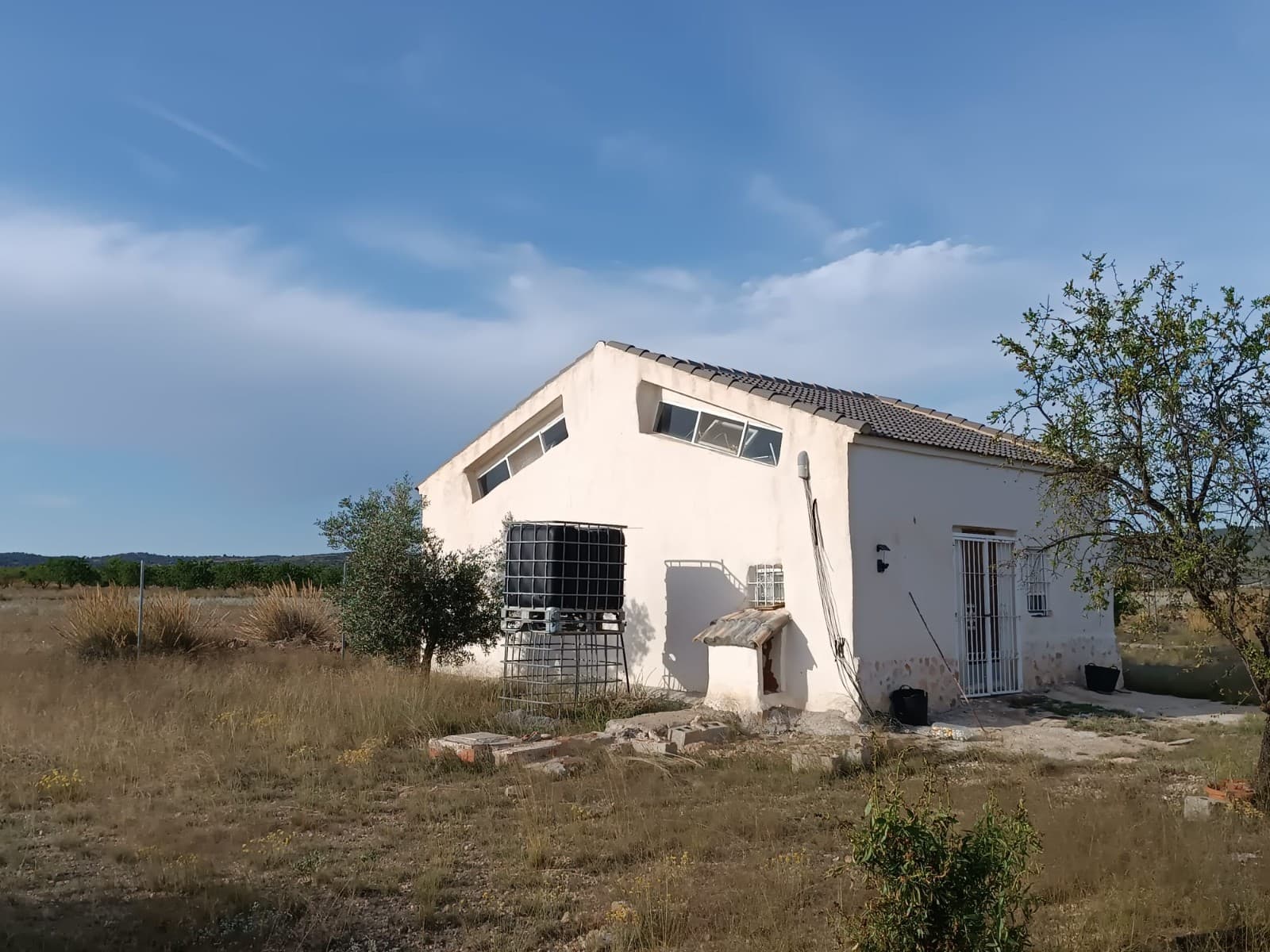 ¿Buscas una inversión viable ? ¿Una aventura agrícola? ¿O simplemente una enorme propiedad privada donde puedas hacer lo que quieras? ¿Todo por menos de 100.000? ¡Has llegado al lugar indicado! Una pequeña casa de campo de 45 m², totalmente reformada, con espacio para un baño y un salón/cocina/dormitorio, ubicada en un jardín vallado de 16.000 m², equipada con una cochera cubierta y un trastero. Además, cuenta con 50.000 m² de olivares centenarios, 20.000 m² de almendros y 50.000 m² de campo para el cultivo de cereales. Tanto el terreno como los árboles están bien cuidados y en plena producción. La propiedad se encuentra en una zona rural tranquila, a 10 km de Yecla. Por 98.000 €, la propiedad ofrece un precio inferior a 1 € por m², además de una casita. ¡No dude en contactarnos para concertar una visita! Sobre la zona: Yecla es famosa por su producción vinícola, sus monumentos históricos y su vibrante cultura local. Los paisajes naturales que la rodean ofrecen la oportunidad de practicar actividades al aire libre, mientras que el pueblo ofrece todos los servicios necesarios, como escuelas, tiendas y restaurantes. Esta propiedad combina la tranquilidad de la vida rural con fácil acceso a servicios modernos. Sobre nosotros: Contamos con una amplia cartera de propiedades en la Costa Blanca y la Costa Cálida, especializándonos en fincas, villas, fincas, terrenos edificables y opciones de diseño y construcción en las regiones de Alicante y Murcia, con especial énfasis en Elda, Monóvar, Pinoso, Sax, Villena, Aspe, Fortuna, Albacete y muchas otras zonas de los alrededores. Llevamos establecidos desde 2004 y nuestro equipo cuenta con décadas de experiencia para ayudarle a encontrar y asegurar la casa de sus sueños. Le acompañamos en cada paso del proceso para garantizar que su compra en España sea segura y sin complicaciones. No estamos aquí para venderle una propiedad, sino para ayudarle a hacer realidad su sueño y encontrar la propiedad perfecta para usted. Con nosotros, está en las mejores manos. Contáctenos ahora para hablar sin compromiso sobre cómo usted también puede hacer realidad sus sueños.