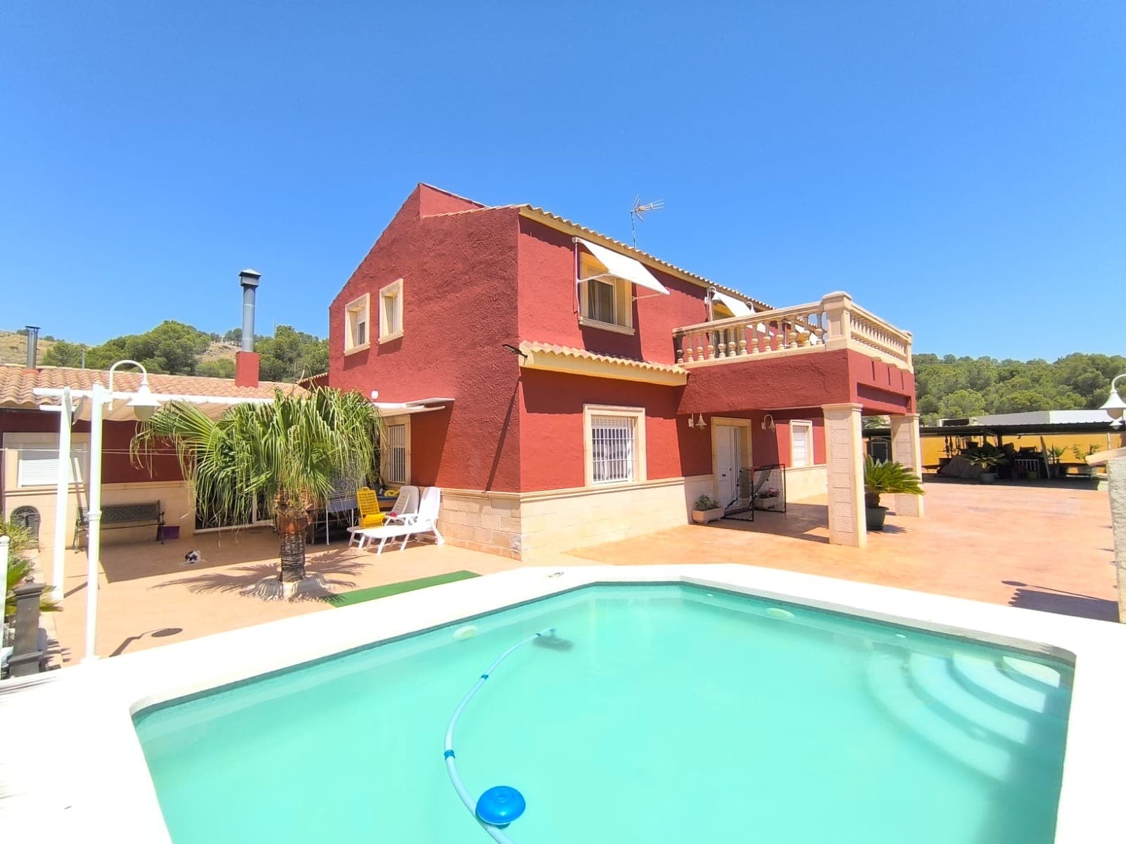 Amplia casa de 6 dormitorios con piscina a solo 1 km de Yecla Esta casa de 300 m² de dos plantas ofrece un amplio espacio habitable, ideal para una familia numerosa o para quienes buscan una cómoda residencia rural cerca del pueblo. La propiedad cuenta con seis dormitorios, dos salones, cocina y tres baños. Está equipada con ventanas de doble acristalamiento con mosquiteras y calefacción central de gasóleo para mayor comodidad durante todo el año. En el exterior, encontrará una piscina privada y 800 m² de terreno completamente vallado con agua potable y luz de red ya conectadas. Sobre el área: Ubicada a solo 1 km de Yecla, en la Región de Murcia, esta casa ofrece un entorno tranquilo con la comodidad de estar a pocos minutos de todos los servicios locales. Yecla es conocida por su producción vinícola, su industria del mueble y su vibrante cultura local. La zona ofrece colegios, supermercados, servicios médicos y una variedad de restaurantes y tiendas, lo que la convierte en un lugar práctico y atractivo para vivir. Su ubicación cerca de la frontera con Alicante también permite un fácil acceso a la costa y al aeropuerto, ambos a aproximadamente una hora. Disponemos de una amplia cartera de propiedades en la Costa Blanca y la Costa Cálida, especializándonos en fincas rústicas, villas, fincas, terrenos edificables y opciones de diseño y construcción en las regiones de Alicante y Murcia, con especial énfasis en Elda, Monóvar, Pinoso, Sax, Villena, Aspe, Fortuna, Albacete y muchas otras zonas de los alrededores. Llevamos establecidos desde 2004 y nuestro equipo cuenta con décadas de experiencia para ayudarle a encontrar y asegurar la casa de sus sueños. Le acompañamos en cada paso del proceso para garantizar que su compra en España sea segura y sin complicaciones. No estamos aquí para venderle una propiedad, sino para ayudarle a hacer realidad su sueño y encontrar la propiedad perfecta para usted. Con nosotros, está en las mejores manos. Contáctenos ahora para hablar sin compromiso sobre cómo usted también puede hacer realidad sus sueños.