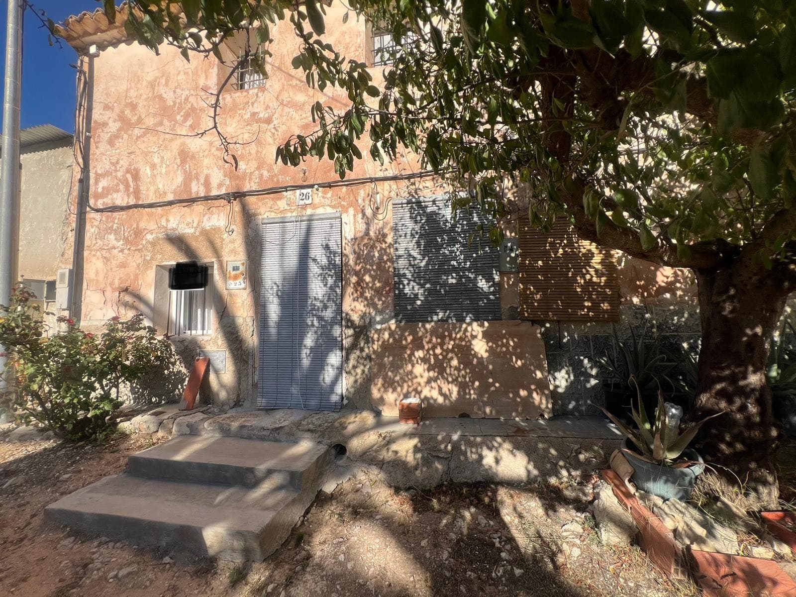This welcoming country house is located in the peaceful hamlet of La Zarza, part of the municipality of Abanilla. While it is semi-detached, the property offers a great sense of privacy and rural atmosphere throughout.The house retains its original charm and structure, offering plenty of potential for personal updates and customization. On the ground floor, you'll find a cozy living room with a fireplace, a large open space ready to be transformed into a kitchen, and direct access to a private patio—ideal for outdoor dining or relaxing in the fresh air. There is one bedroom downstairs and a spacious hallway upstairs that leads to two additional bedrooms, providing flexibility for family living or guest accommodation.Connected to electricity and water supply, the house also features a private water well—an added benefit for gardening or other uses.Outside, the property includes two plots of land: one smaller plot with a mature olive tree, and another larger, fenced plot that contains 14 almond trees. These outdoor spaces offer a wide range of possibilities, from creating a vegetable garden or leisure area to developing a small agricultural project or simply enjoying the natural setting.About the Area La Zarza is a quiet rural village surrounded by nature, yet just 20 minutes from the town of Pinoso, known for its local markets, restaurants, and services. The area is ideal for those looking to enjoy a slower pace of life while staying connected to nearby towns. It's perfect for nature lovers, walkers, and anyone looking to settle or invest in a peaceful setting with traditional Spanish charm.This property is a great opportunity to create a comfortable countryside home tailored to your taste, with both indoor and outdoor space to enjoy.We have a large portfolio of properties in the Costa Blanca and Costa Calida areas, specialising in country properties, villas, fincas, building plots and design and build options in the Alicante and Murcia regions with a particular emphasis on Elda, Monovar, Pinoso, Sax, Villena, Aspe, Fortuna, Albacete and many more surrounding areas. We have been established since 2004 and have decades of experience between the team which we bring to bear to help you find and secure your new dream home. We help you every step of the way to make sure your purchase in Spain is safe and hassle free. We are not here to sell you a property, we are here to help you realise your dream and find what is right for you. With us you are in the safest hands. Contact us now to have a no obligation chat about how you too can realise your dreams.