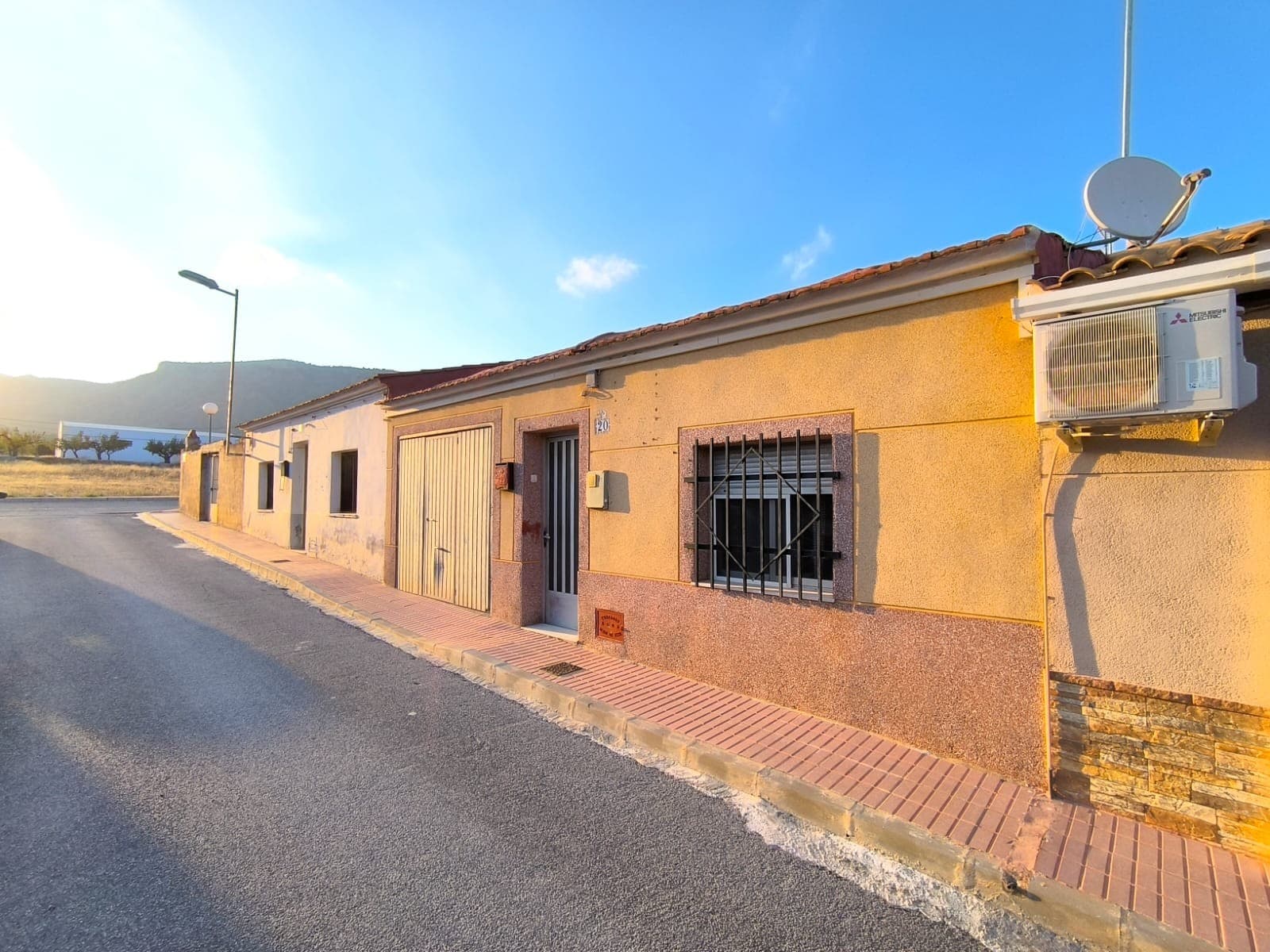 Exquisita casa adosada lista para mudarse en Salinas. La propiedad cuenta con dos amplios dormitorios (y un espacio especial para uno más), un espacioso salón, una práctica cocina, un baño, un pequeño patio y un garaje/taller. La casa ha sido reformada con estándares modernos (incluyendo techo y ventanas), se vende amueblada y está lista para recibir a nuevos inquilinos. Ubicada a las afueras del pueblo, la casa se encuentra a poca distancia del animado centro de Salinas y de todas sus tiendas, bares y otros servicios, pero también muy cerca de pintorescos senderos de montaña en un entorno natural privilegiado. Conectado a la red de agua potable, electricidad y alcantarillado, todo el cableado y la plomería están actualizados. Sobre la zona: Enclavado en la pintoresca campiña de la provincia de Alicante, Salinas es un encantador y tranquilo pueblo de casi 1800 habitantes, conocido por sus impresionantes vistas a las montañas, su encanto tradicional español y su acogedora comunidad. Rodeado de montañas y exuberantes paisajes, ofrece un estilo de vida tranquilo a tan solo 40 minutos de la costa y del aeropuerto de Alicante. Ideal para quienes buscan un entorno rural relajado con fácil acceso a servicios modernos, Salinas es perfecto para casas de vacaciones, para jubilados o como residencia permanente tranquila. La zona cuenta con propiedades asequibles, hermosos senderos para caminar y un clima mediterráneo templado durante todo el año. Sobre nosotros: Disponemos de una amplia cartera de propiedades en la Costa Blanca y la Costa Cálida, especializándonos en fincas, villas, fincas, terrenos edificables y opciones de diseño y construcción en las regiones de Alicante y Murcia, con especial énfasis en Elda, Monóvar, Pinoso, Sax, Villena, Aspe, Fortuna, Albacete y muchas otras zonas de los alrededores. Llevamos establecidos desde 2004 y nuestro equipo cuenta con décadas de experiencia para ayudarle a encontrar y asegurar la casa de sus sueños. Le acompañamos en cada paso del proceso para garantizar que su compra en España sea segura y sin complicaciones. No estamos aquí para venderle una propiedad, sino para ayudarle a hacer realidad su sueño y encontrar la propiedad perfecta para usted. Con nosotros, está en las mejores manos. Contáctenos ahora para hablar sin compromiso sobre cómo usted también puede hacer realidad sus sueños.