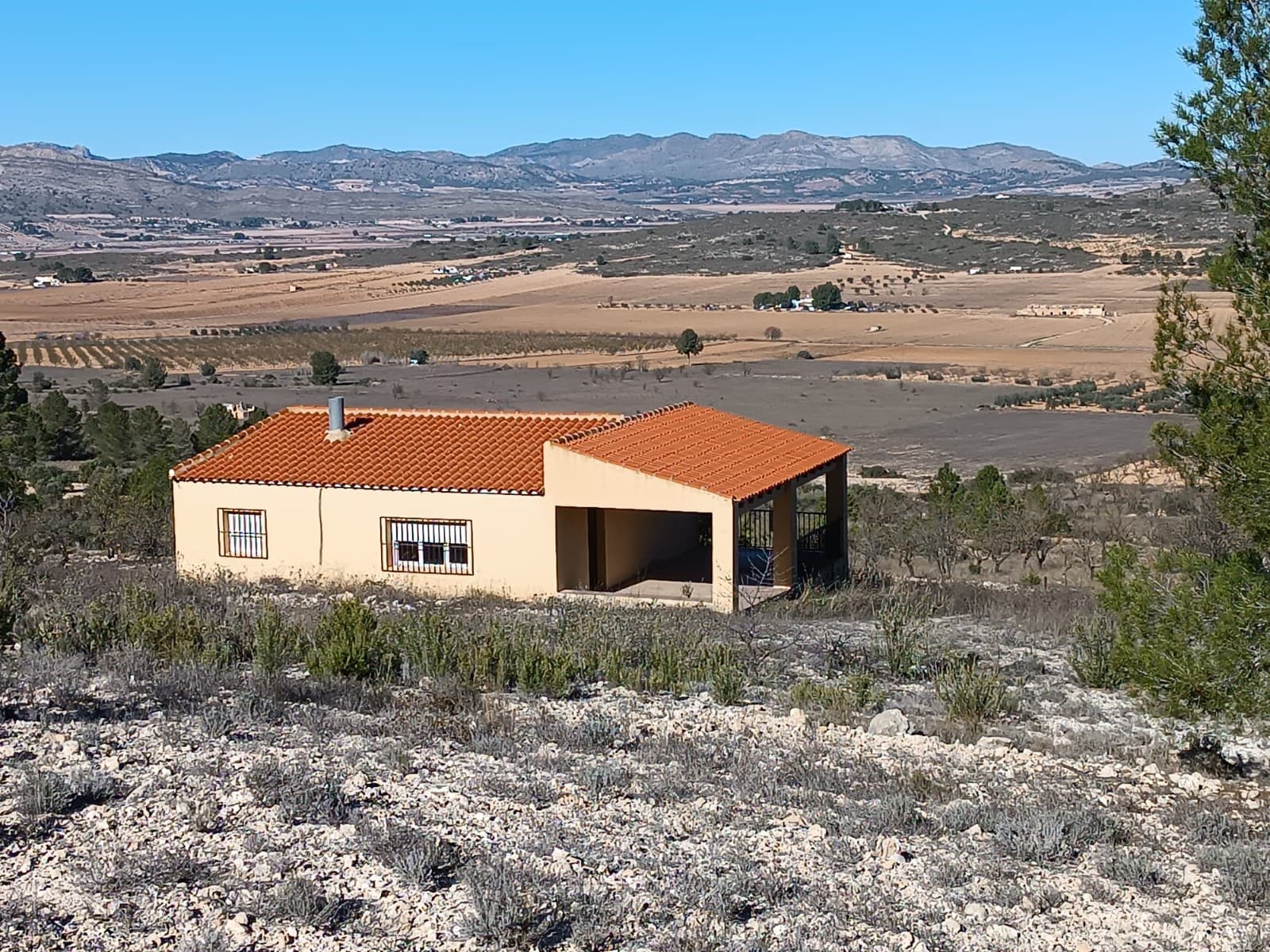 Set in exceptionally peaceful and picturesque natural area, this charming country house offers a truly privileged setting surrounded by mountains and spectacular panoramic views - the perfect backdrop for those seeking tranquillity, nature and open landscapes.The property sits on a generous 14,000 m² plot with almond trees and ample space for a variety of uses. Its unfenced layout enhances the sense of freedom and makes it especially suitable for horses, dogs, or outdoor enthusiasts.The 90 m² home is designed for comfort and simplicity. It features a large porch ideal for outdoor meals and relaxed gatherings, a cosy living room with fireplace, an independent and functional kitchen, 3 bedrooms, and 1 bathroom with a shower. Two water cisterns provide supply, making the property suitable for off-grid living. The house is structurally sound, but requires some work - wiring and solar panels, furnishing etc.Despite its privacy and natural surroundings, the house is located just a few minutes drive from the town centre of Yecla, offering the perfect balance between seclusion and convenience.A wonderful opportunity for those who value nature, space and serene mountain views.About the area: Yecla is a charming and historic town of app. 35000 inhabitants, located in the region of Murcia. It is renowned for its award-winning wines, historical landmarks, and vibrant local culture. The surrounding natural landscapes of scenic mountains, vineyards and almond groves provide opportunities for outdoor activities, while the town itself offers all necessary services, including hospital, schools, shops, restaurants, and other services. With a friendly local community, lively markets, excellent gastronomy, and easy access to nature, Yecla is an ideal location for those seeking authentic Spanish lifestyle - just about an hour from the coast and Alicante airport.About us: We have a large portfolio of properties in the Costa Blanca and Costa Calida areas, specialising in country properties, villas, fincas, building plots and design and build options in the Alicante and Murcia regions with a particular emphasis on Yecla, Novelda, Elda, Monovar, Pinoso, Sax, Villena, Aspe, Fortuna, Jumilla, Abanilla, and many more surrounding areas. We have been established since 2004 and have decades of experience between the team which we bring to bear to help you find and secure your new dream home. We help you every step of the way to make sure your purchase in Spain is safe and hassle free. We are not here to sell you a property, we are here to help you realise your dream and find what is right for you. With us you are in the safest hands. Contact us now to have a no obligation chat about how you too can realise your dreams.