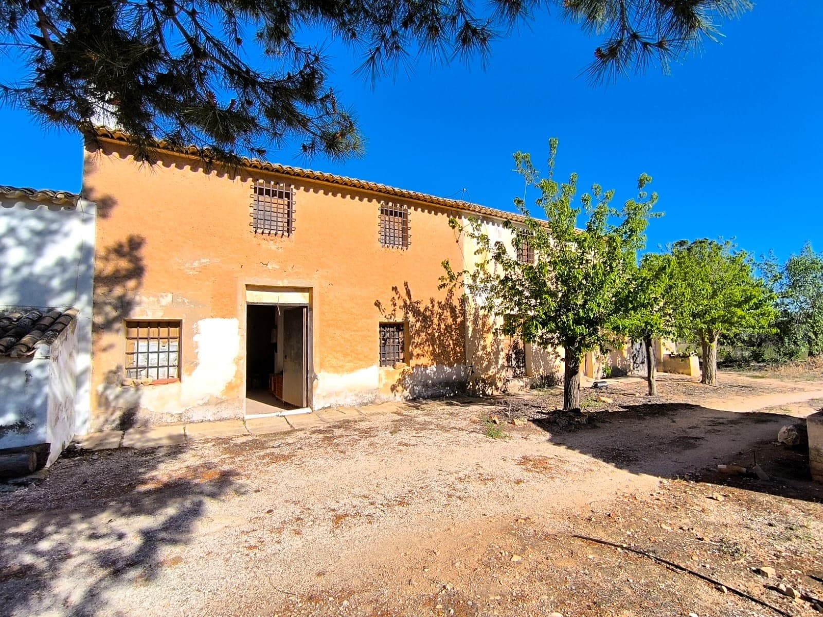 Two of our properties combined for sale! This property comprises of two adjacent houses, both to reform. Each of them has 2 accesses, and traditional features such as exposed wooden beams, stone pillars, large rustic fireplaces, creating a warm and characterful atmosphere.The first house, in the centre, is in better shape, with solid, thick stone walls and a sound roof provide a reliable structure. The property comprises a two-floor living unit, a patio with storage and a water deposit, rooms for animals, and a large garage, offering plenty of potential for various uses.The second house requires a complete structural reform, including the roof and some walls. Neither of the houses is currently habitable, equipping and renovations are need. Thanks to its size and rustic charm, this property presents an interesting opportunity to design and restore a unique countryside home for various goals.The property also includes land, just a few metres from the house: olives groves and a garden with fruit trees of 1200 m2, perfect for enjoying outdoor living and a self-sufficient lifestyle. Convenient access via a tarmac road ensures easy year-round reach.Located just 10 km, 10 minutes from town, in a peaceful and tranquil countryside setting with open surroundings. Contact us for a commented walkthrough video.About the area: Yecla is a charming and historic town of app. 35000 inhabitants, located in the region of Murcia. It is renowned for its award-winning wines, historical landmarks, and vibrant local culture. The surrounding natural landscapes of scenic mountains, vineyards and almond groves provide opportunities for outdoor activities, while the town itself offers all necessary services, including hospital, schools, shops, restaurants, and other services. With a friendly local community, lively markets, excellent gastronomy, and easy access to nature, Yecla is an ideal location for those seeking authentic Spanish lifestyle - just about an hour from the coast and Alicante airport.About us: We have a large portfolio of properties in the Costa Blanca and Costa Calida areas, specialising in country properties, villas, fincas, building plots and design and build options in the Alicante and Murcia regions with a particular emphasis on Yecla, Novelda, Elda, Monovar, Pinoso, Sax, Villena, Aspe, Fortuna, Jumilla, Abanilla, and many more surrounding areas. We have been established since 2004 and have decades of experience between the team which we bring to bear to help you find and secure your new dream home. We help you every step of the way to make sure your purchase in Spain is safe and hassle free. We are not here to sell you a property, we are here to help you realise your dream and find what is right for you. With us you are in the safest hands. Contact us now to have a no obligation chat about how you too can realise your dreams.